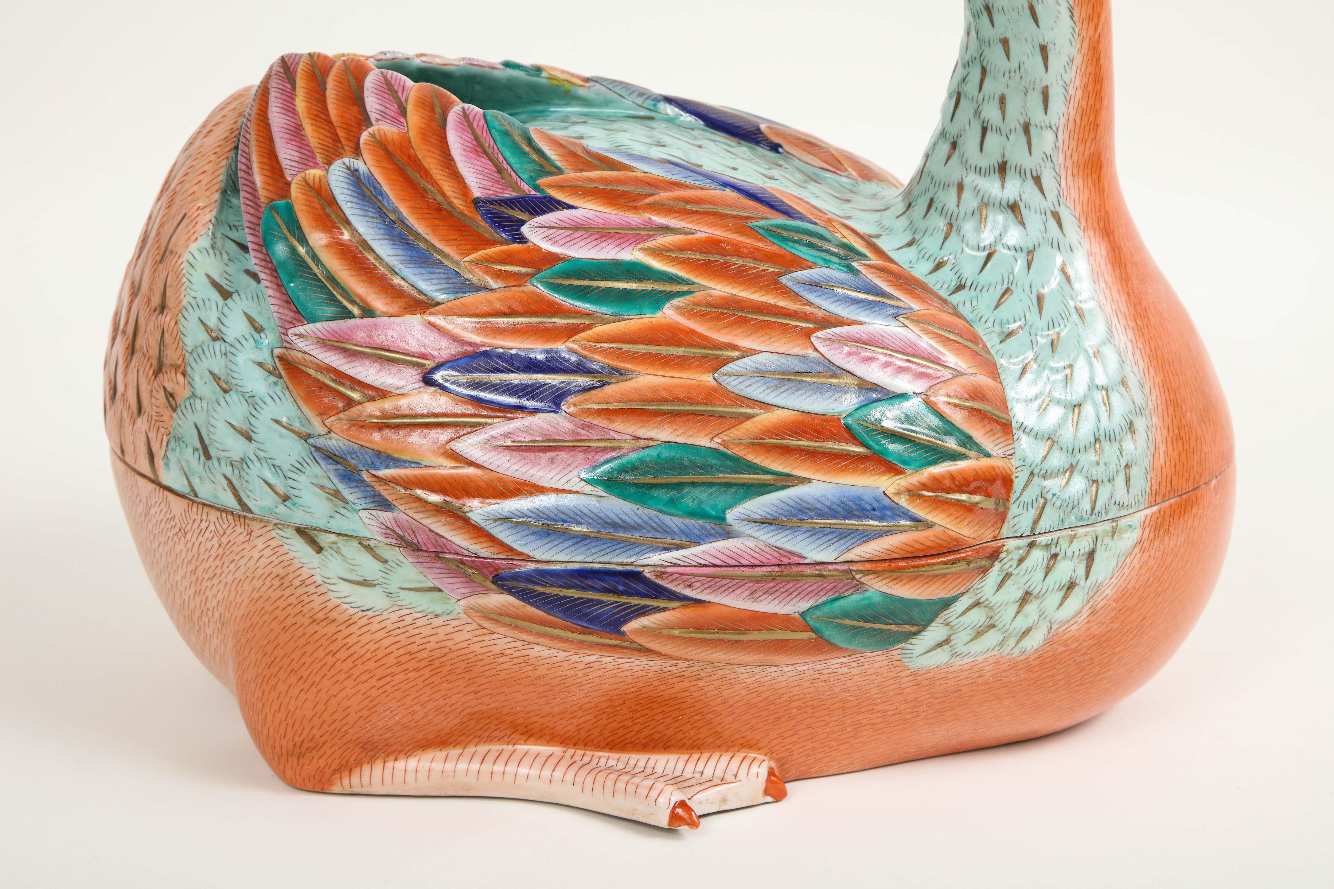 In the form of a sitting duck after 18th century models and in two parts; decorated profusely in aqua, orange, and cobalt blue with gilt highlights.