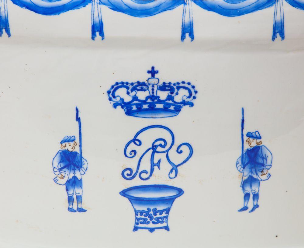 With applied handles to the sides, painted in blue monochrome with band of swags under the rim, over crown, shield motifs and sparse stylized flowers; the interior with three leaves and crossing palm fronds, branches motifs in a band near base