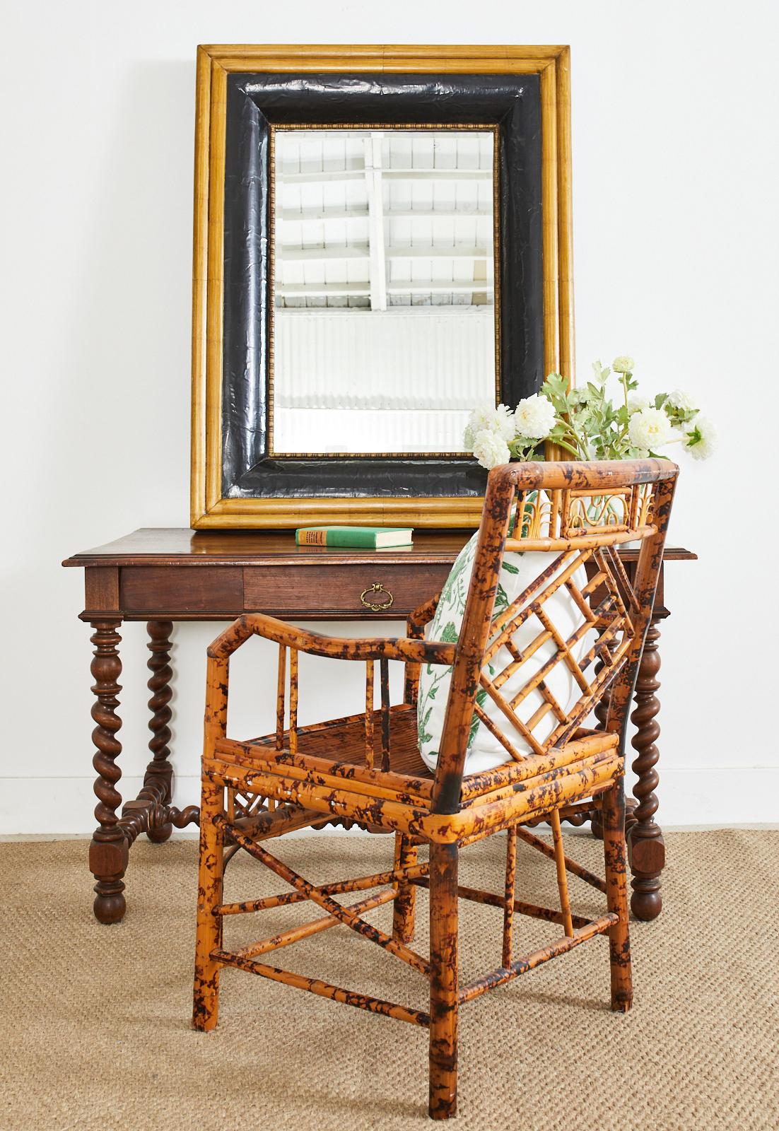 Brighton pavilion style Chinese export bamboo armchair featuring Chinese chippendale rattan fretwork. The chair frame is crafted from gorgeous tortoise shell style bamboo with dramatic color and patterns. Beautifully crafted with strong joinery and