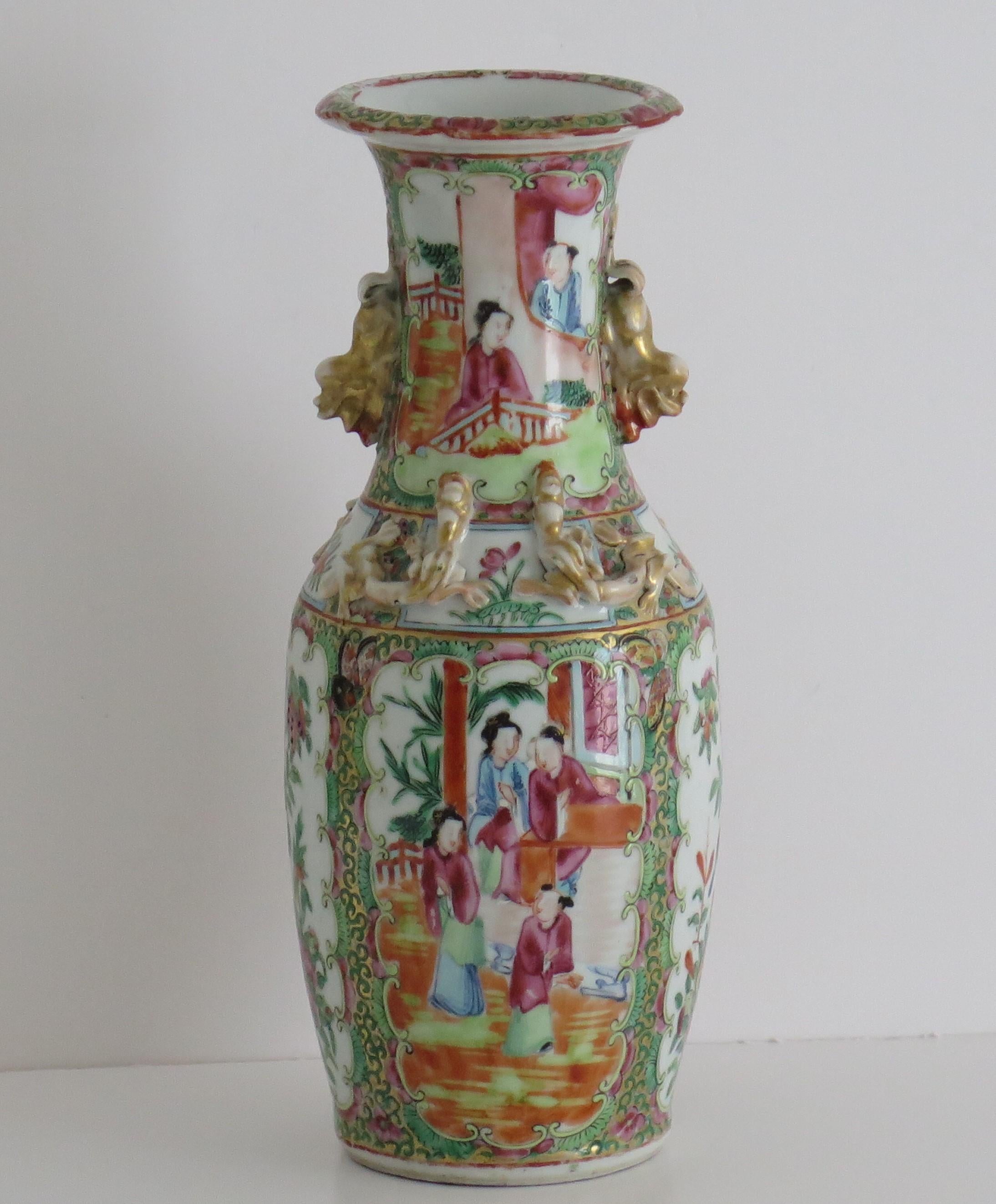 This is a very decorative Chinese export, Canton porcelain, rose medallion Vase which we date to the 19th century, Qing dynasty, circa 1840.

The vase has a baluster shape with a flared rim and is embellished with two gilded Foo Dog handles and