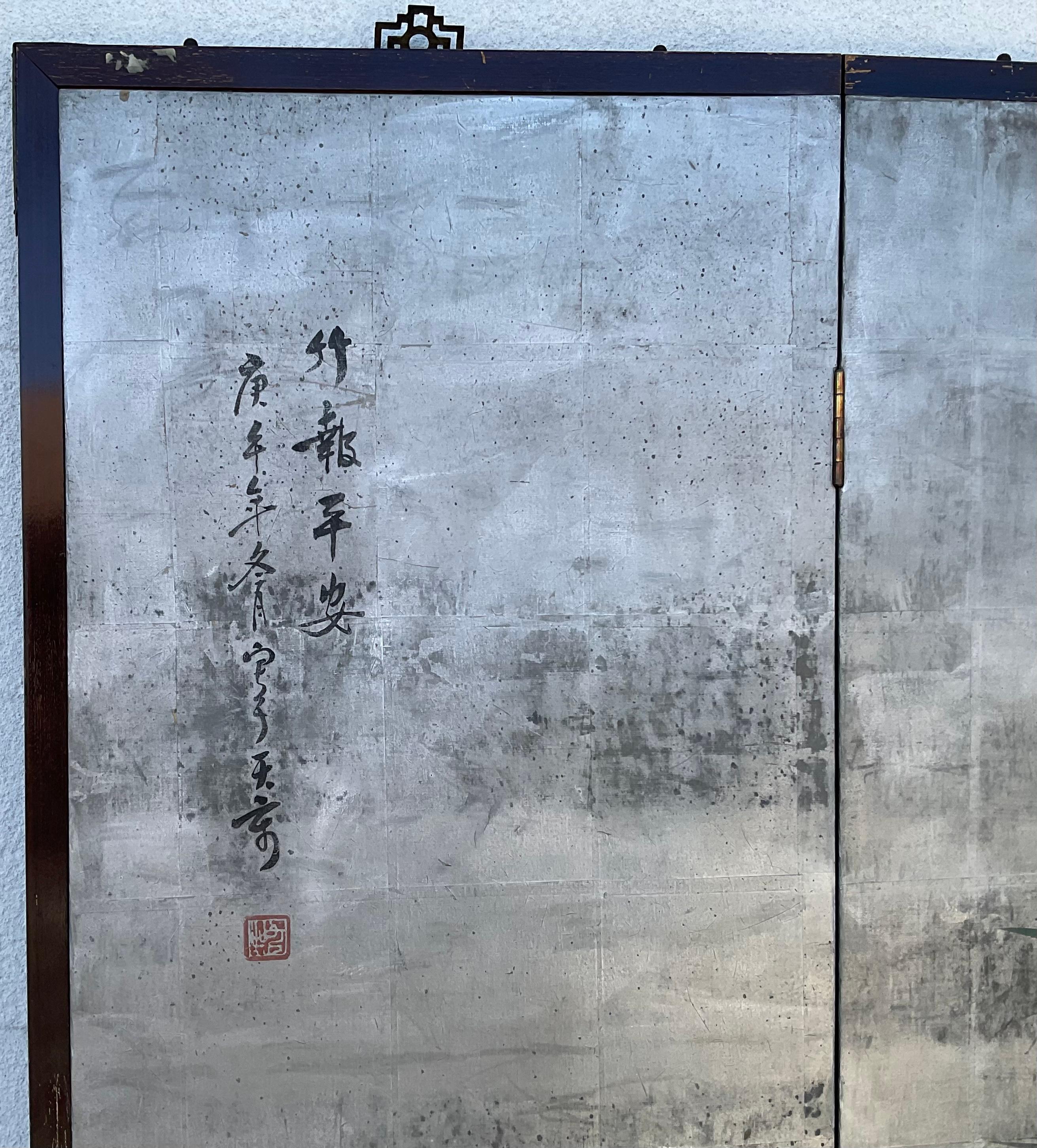 Chinese export wallpaper four panel screen, each panel depicting a variety of cranes and flowering prunus branches on a silver blue ground, between, on a traditional wood-trimmed screen. Signed in the upper left side. Bright vivid colors throughout.