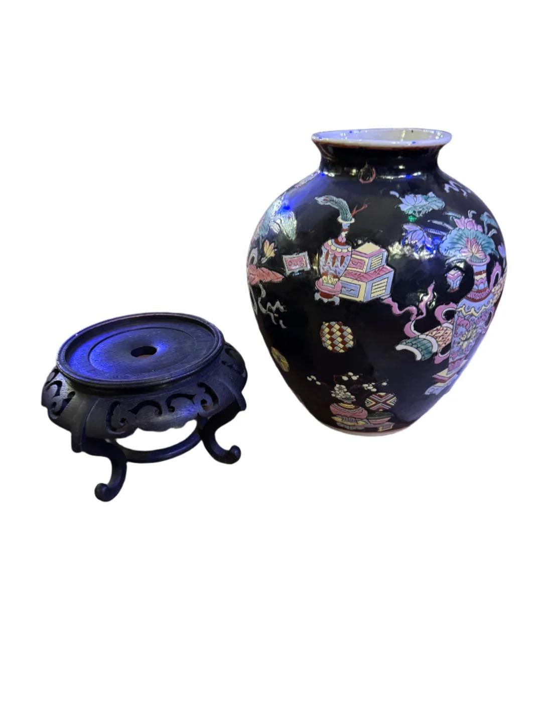 Vaso in porcellana nera smaltata Famille Noire cinese d'epoca, vaso per zenzero con supporto in Wood

Questo vaso è un'aggiunta straordinaria a qualsiasi arredamento. Caratterizzato da una ricca base in porcellana nera ornata da vivaci motivi