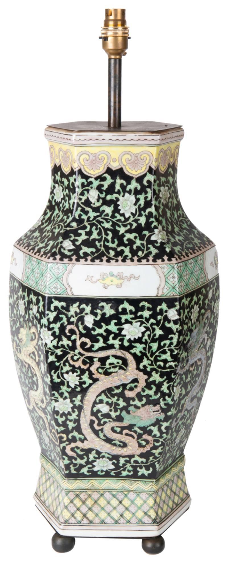 A good quality 19th century Chinese famille verte vase or lamp. Having a black ground with green foliatre decoration, and a mythical Dragon amongst. Boarders in yellows and greens and raised on bronze ball feet.