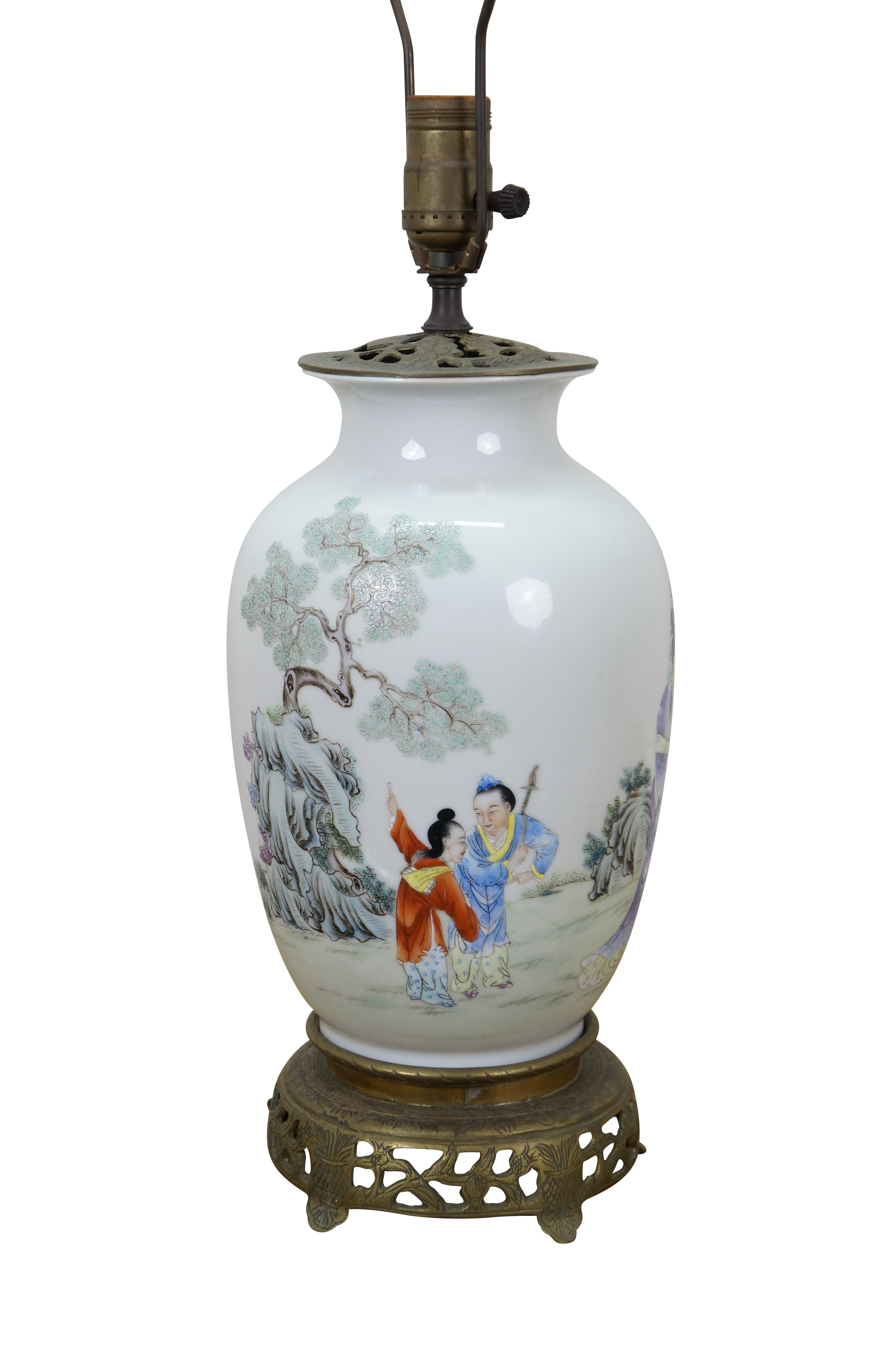 Mid century Chinese chinoiserie Famille Rose ginger jar / vase / urn table lamp with pierced brass base and top. White porcelain body hand painted with a scene of warriors and scholars at the base of a gnarled tree.  Includes harp and white resin