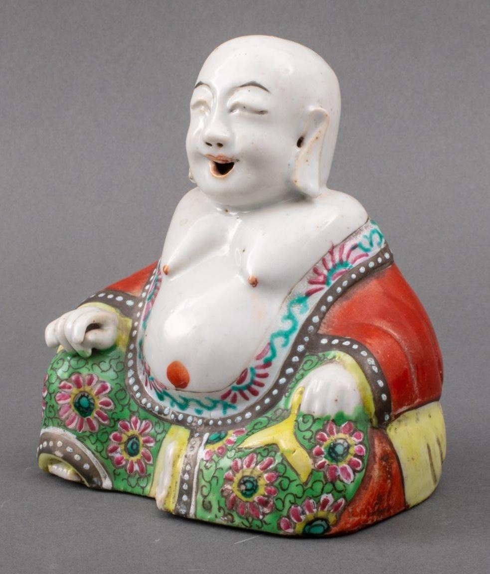 Chinese famille rose porcelain figure of Budai / Happy Buddha seated and wearing a copper red glazed robe with green scrolling floral pattern, with holes at ears, nose, and mouth and an opening at base to be used as an incense burner, 19th century.