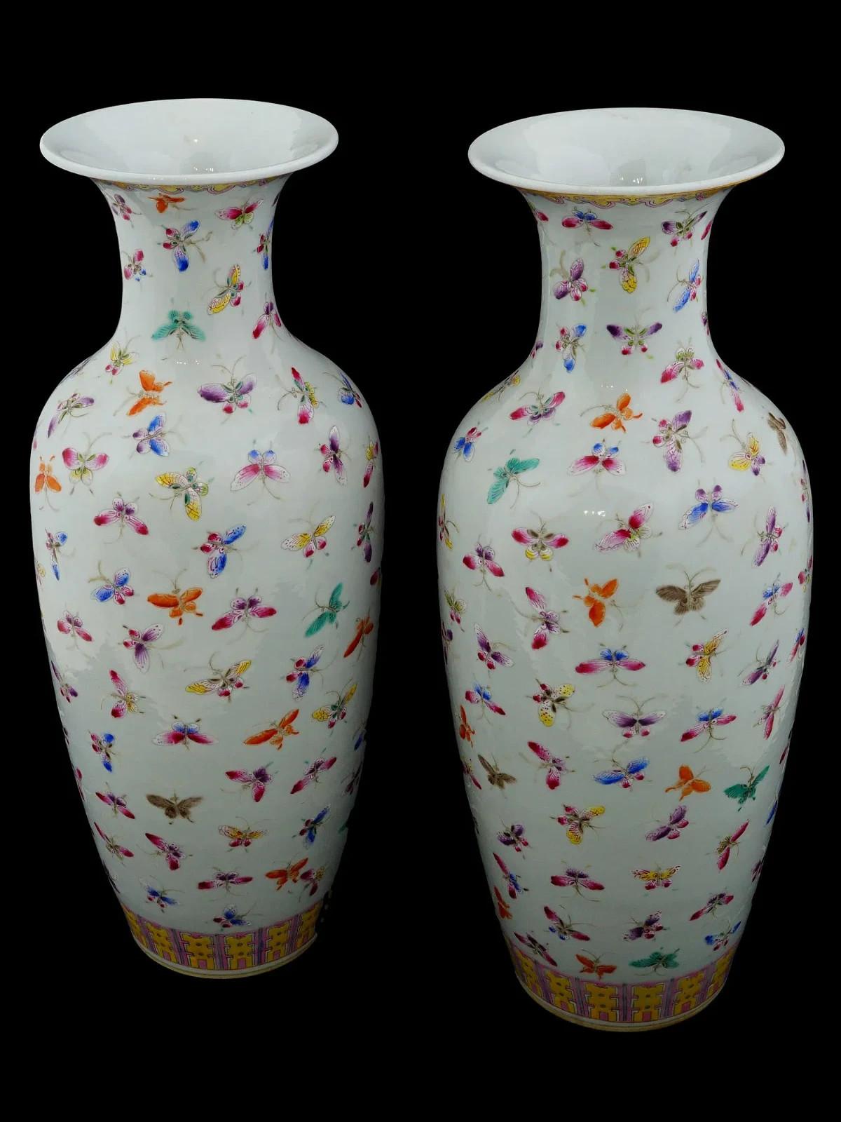 Pareja de jarrones antiguos chinos de porcelana Famille Rose. Cada jarrón tiene un cuerpo en forma de urna con boca estriada. Los exteriores están brillantemente esmaltados con el motivo de las Cien Mariposas, dividido por una ancha banda de