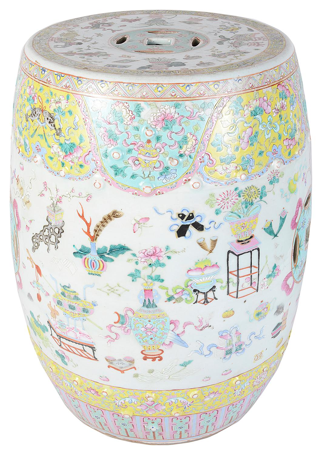 A good quality Chinese Famille rose porcelain garden seat, having turquoise and yellow ground with classical flowers, motifs, the central ban with ribbons, vases of flowers and various furniture etc. The seat and sides with piercing.