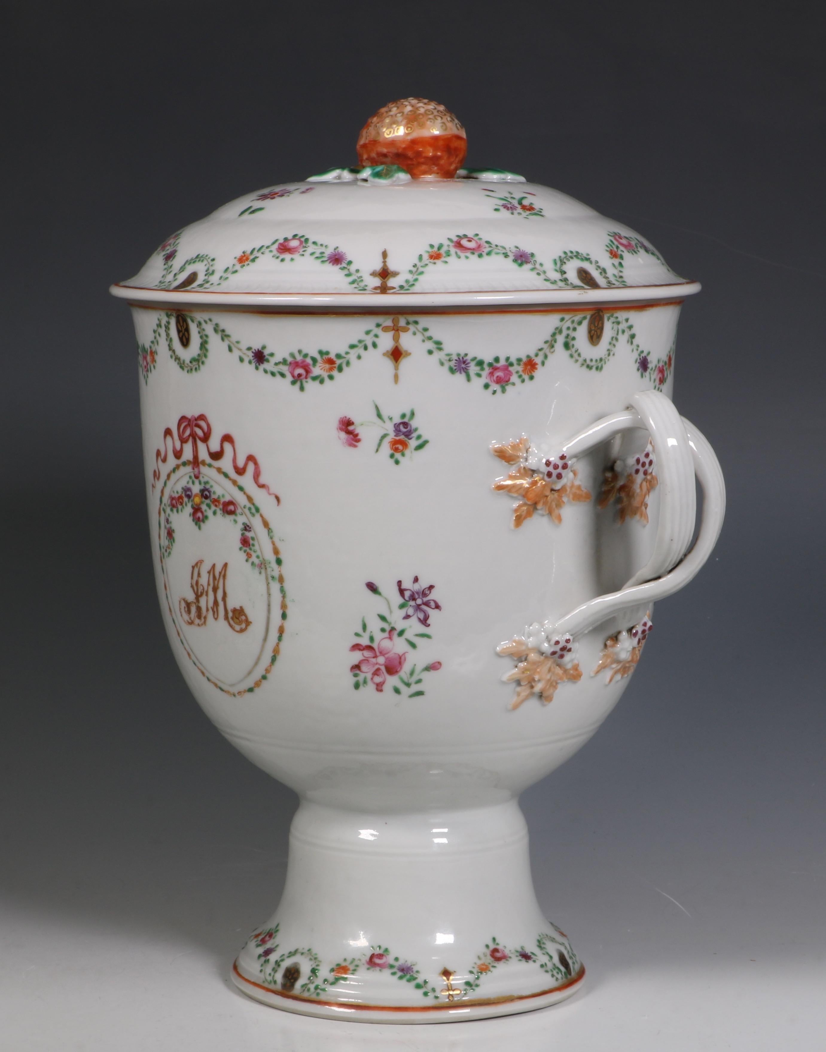 A Chinese Famille rose twin handled loving cup and cover. Decorated with a J M monogram below floral swags. The domed cover with a strawberry finial.
Qianlong, circa 1790.