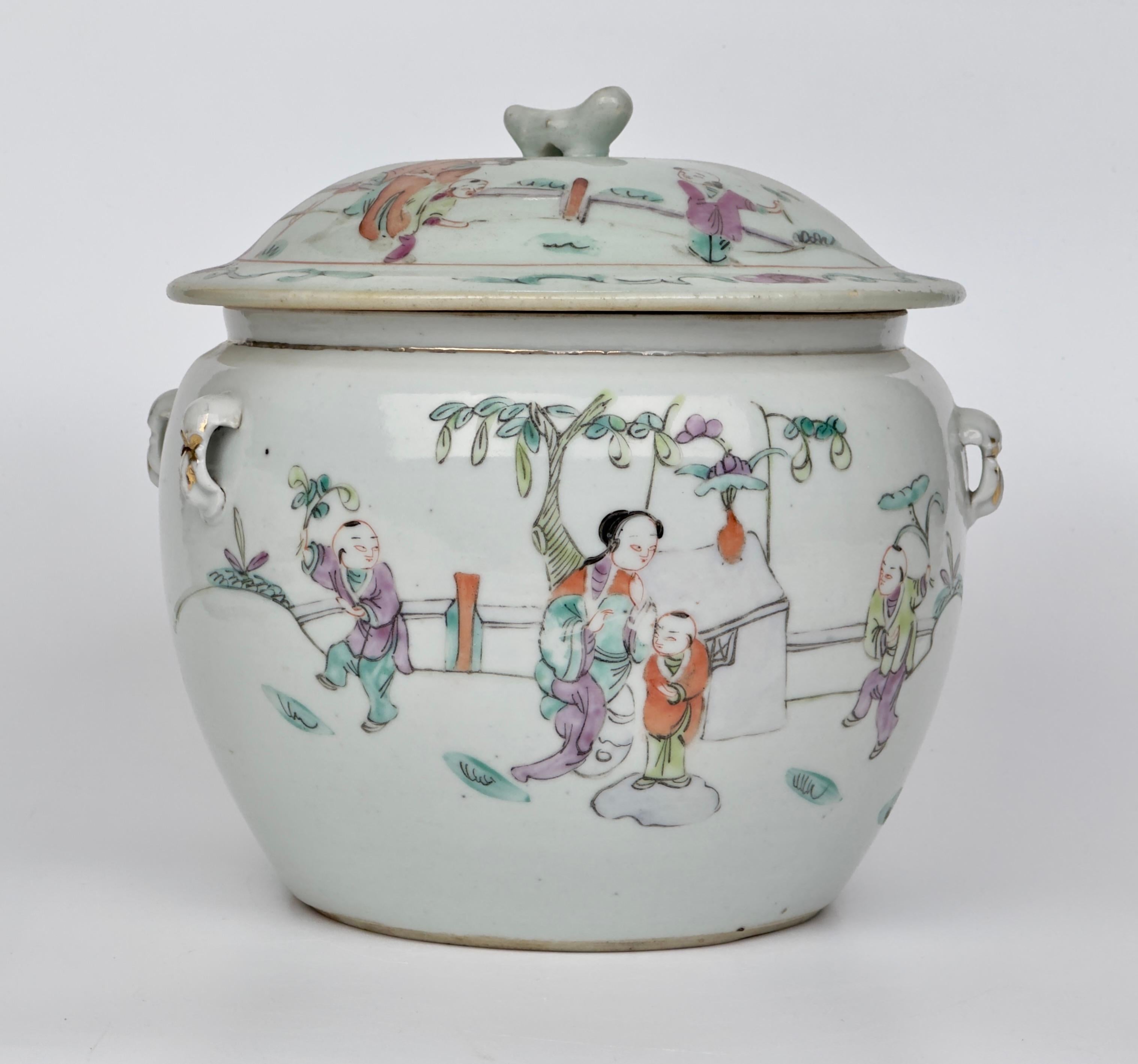 Kamcheng Bowl and Cover. It is decorated throughout with hand painted scenes of figures in the outdoors and probably in celebration. On one side a figure wearing vivid orange is riding a mythical creature while the other figures wear purple and are