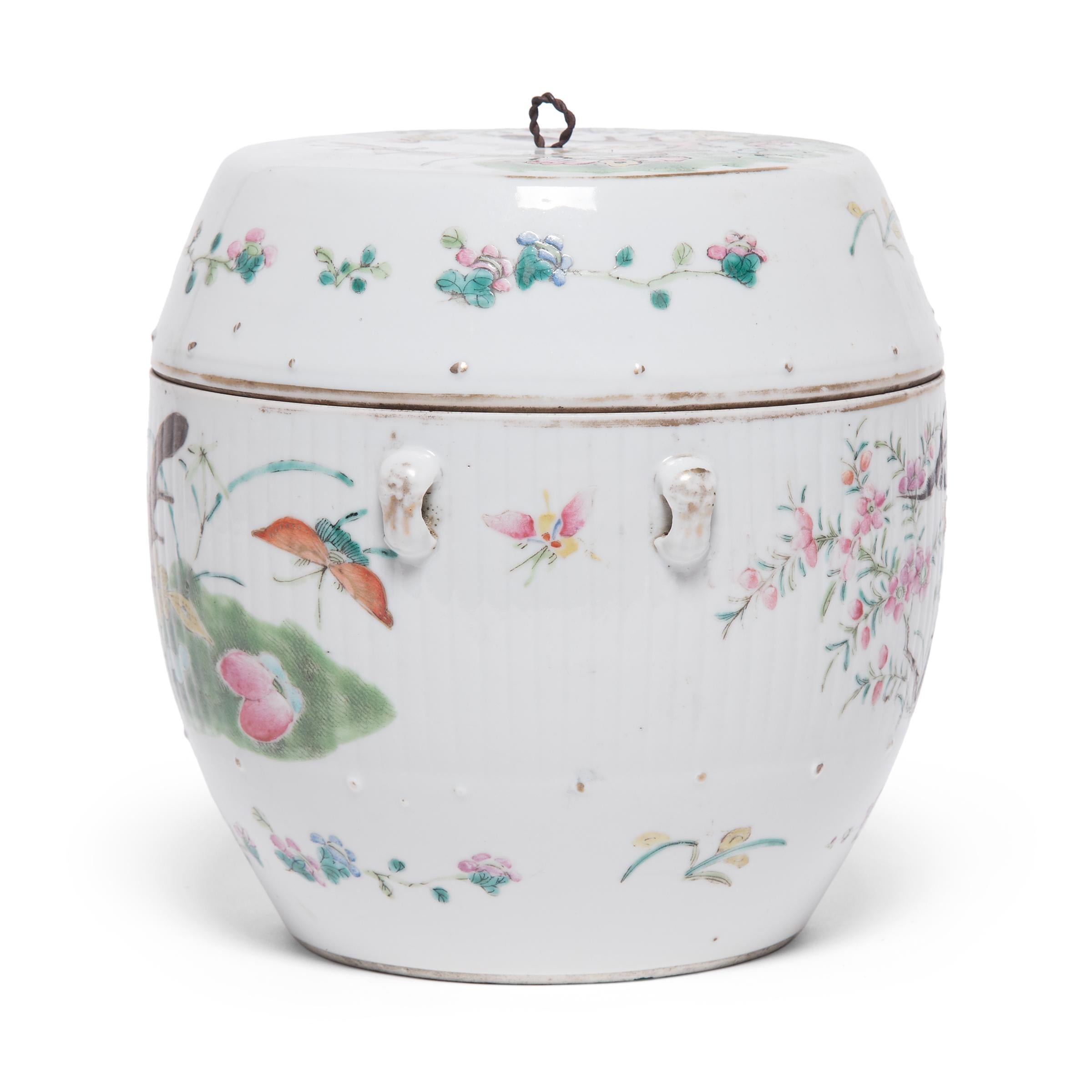 This early 20th century covered jar takes its rounded shape from serving tureens used to serve soups and stews. Contrasted by a crisp white field, the lid and sides are decorated with a joyous garden scene. Butterflies and cicadas flit between