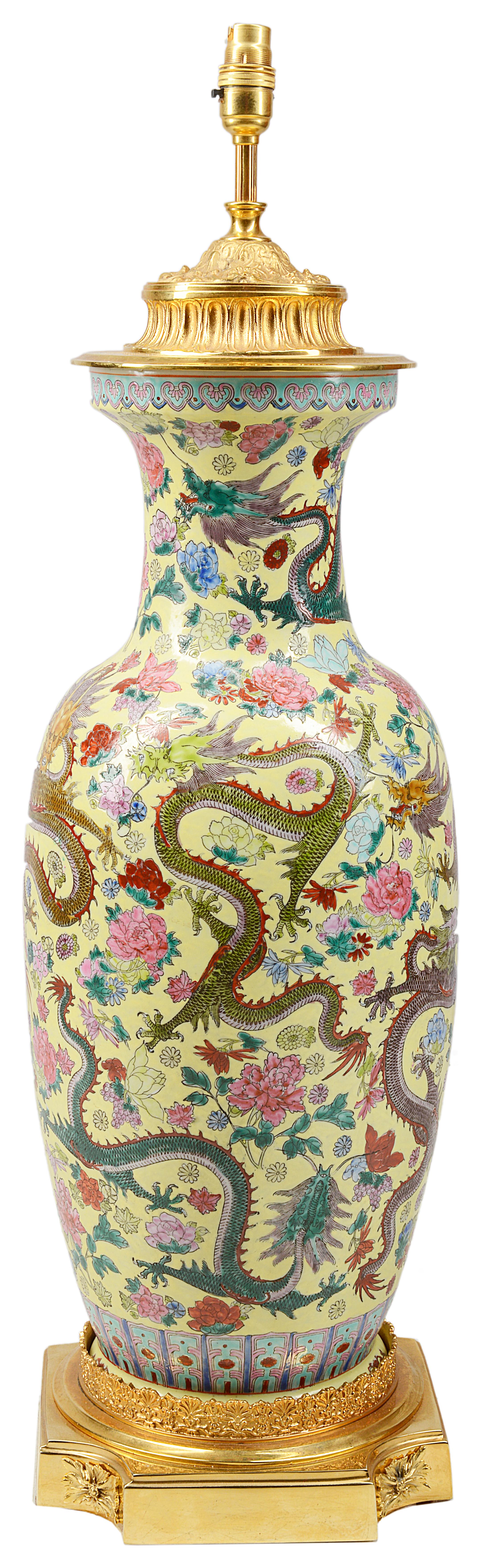 A good quality 19th century style Chinese Famille Rose porcelain vase, having mythical Dragons, flowers and foliage to the yellow ground. Mounted on gilded ormolu base and top.