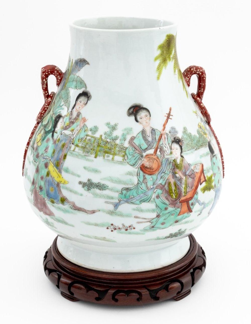 Chinese Famille Verte Porcelain Hu Vase, hand-enameled with courtly landscape and with two applied loop form handles, blue underglaze six character mark to underside, together with carved wood stand. Vase: 10.5