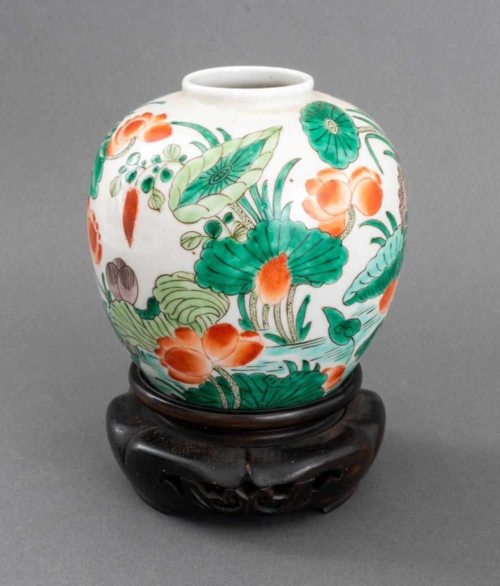 Chinese Famille Verte Glazed Porcelain Vase, globular form hand-painted with lotus flower motif, together with carved wood stand.

Vase: 5.25