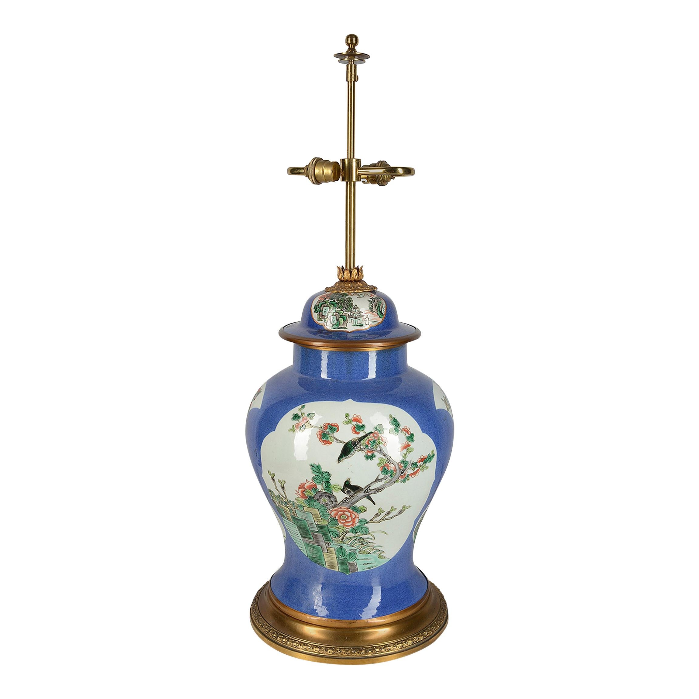 A very good quality Chinese 19th century Famille verte vase / lamp. Having a blue ground with inset painted panels depicting exotic flowers and birds. Mounted on an ormolu base with finial.