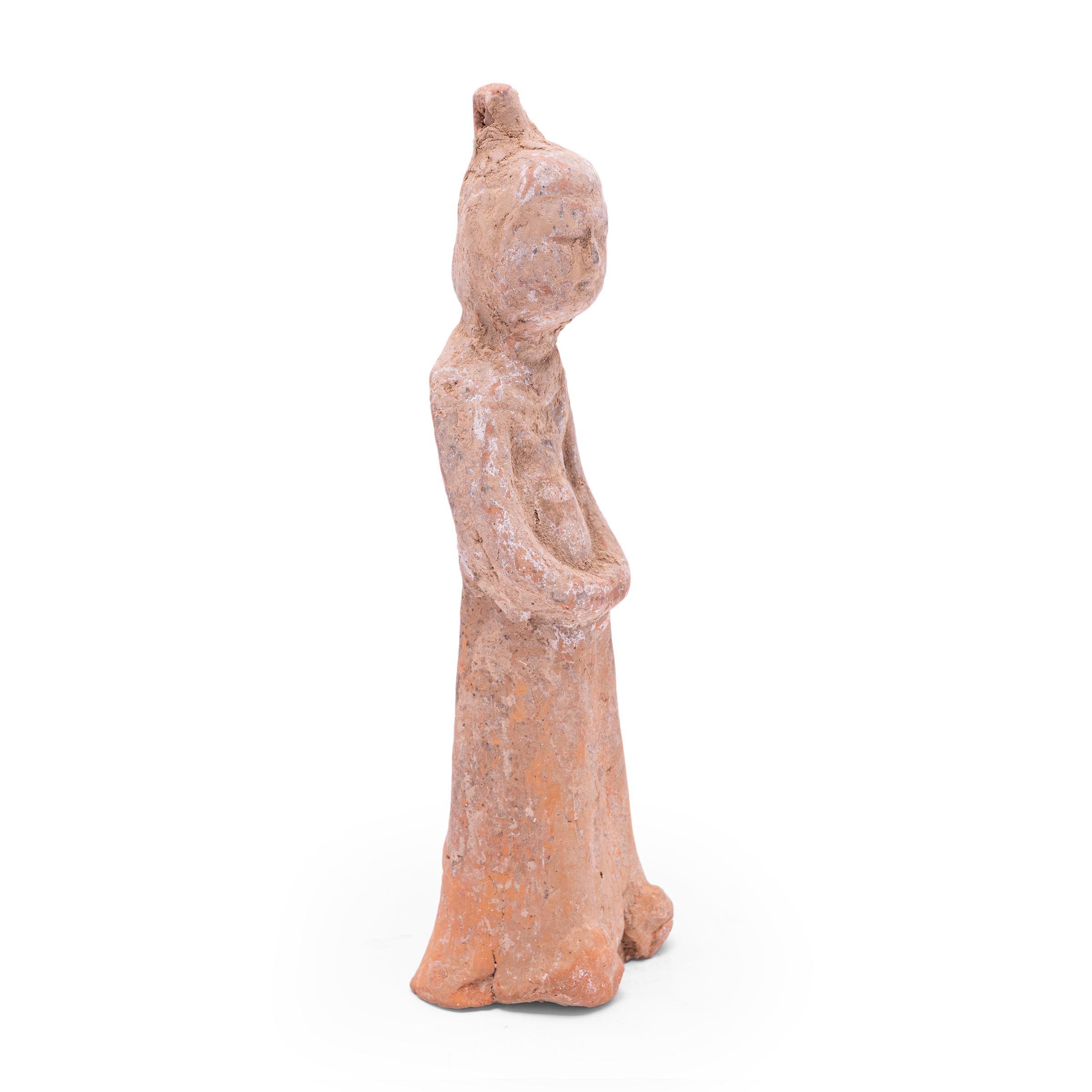 Moulée en terre cuite, cette petite sculpture est un type de figurine funéraire vieille de plusieurs siècles, connue sous le nom de míngqì. Ces figurines étaient placées dans les tombes des personnes de haut rang pour leur assurer un voyage en toute