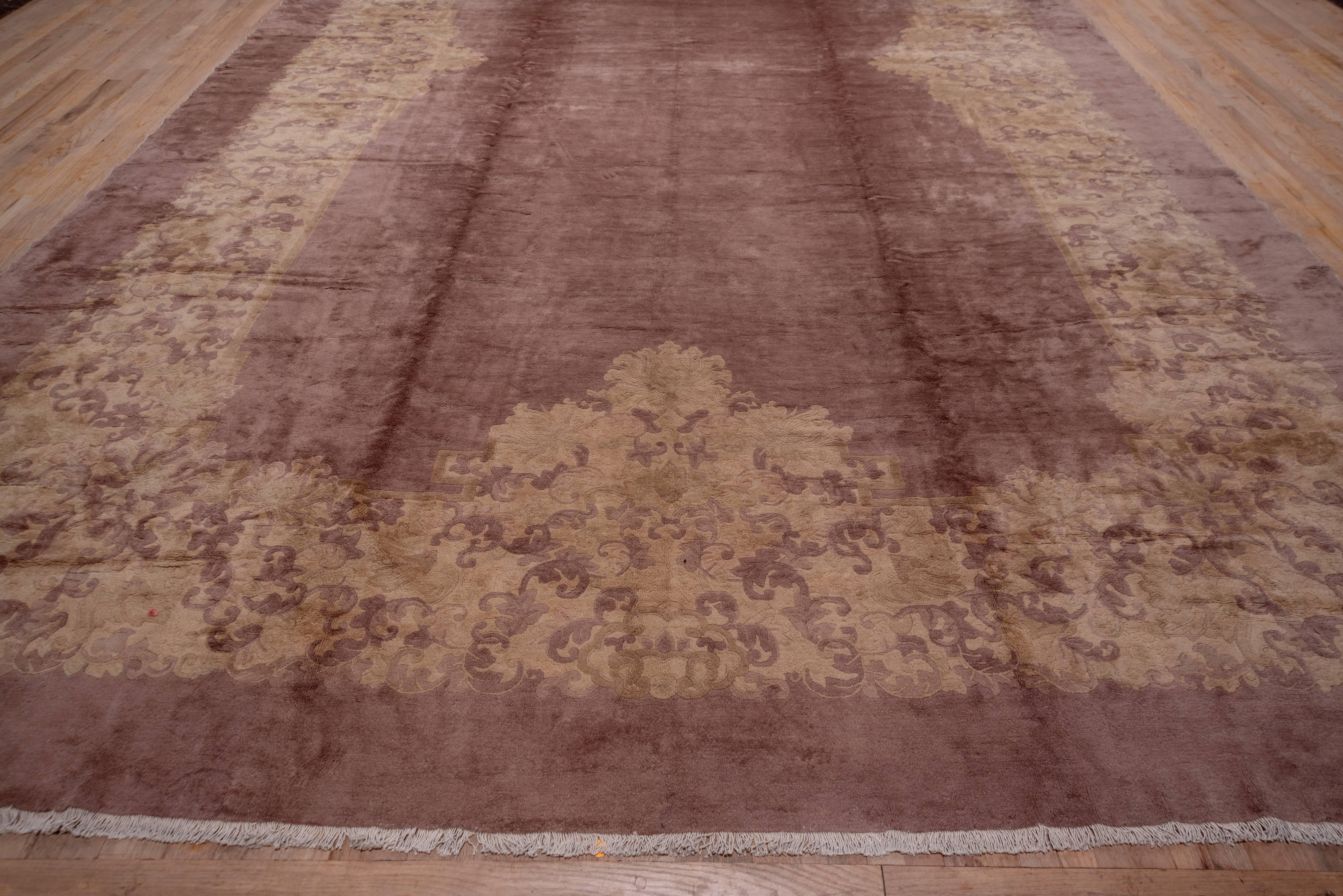 The Fette workshop was active in Peking in the interwar period and specialized in light-toned carpets with influences from early Chinese textiles, jades and bronzes. The open tan field of this large Fette is surrounded by and elaborate golden beige