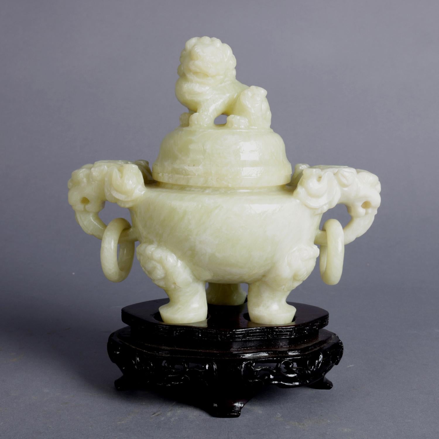 Asian figural censer features cave soapstone construction having lid with foo dog finial and double elephant handled bowl raised on elephant legs, seated on carved hardwood display Stand, 20th century.

Measures: 7.75