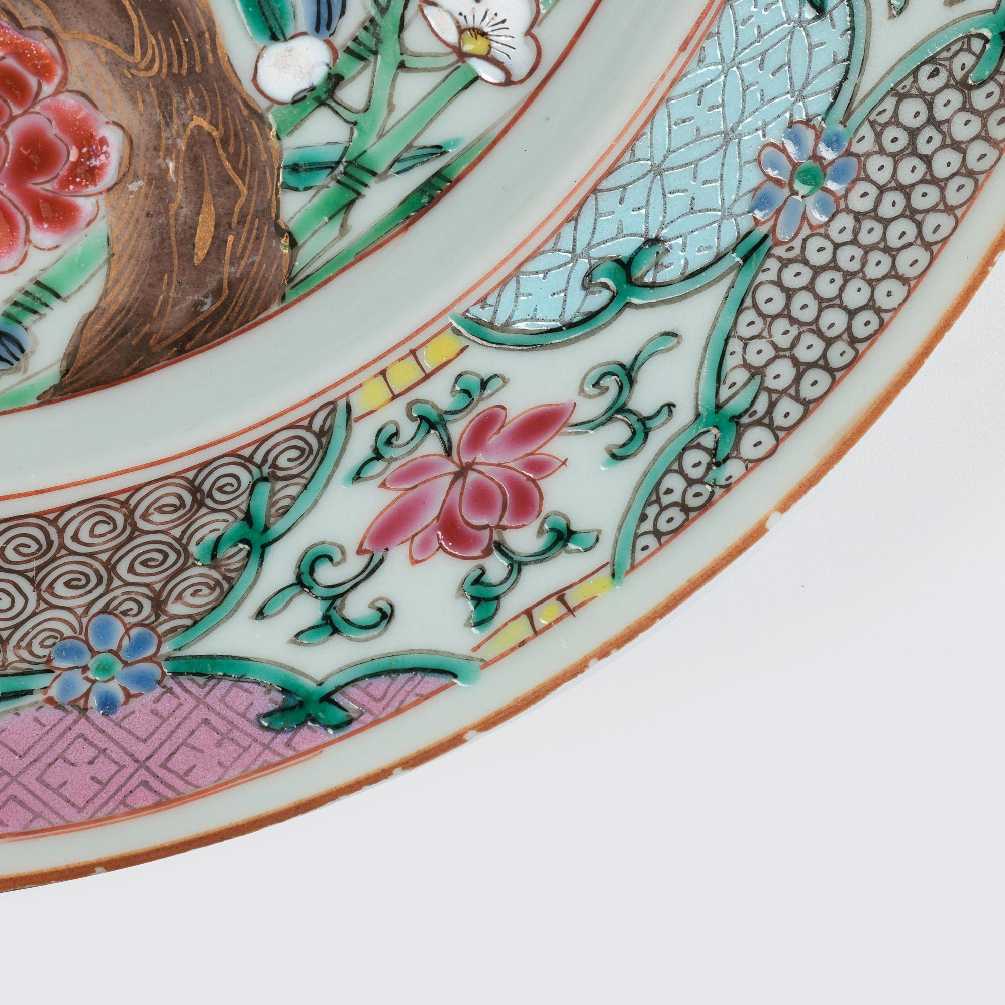 A very fine antique Chinese Qianlong porcelain hand painted famille rose plate with floral designs dating from the 18th century. The lightly potted plate is of rounded shape standing on a carved unglazed foot and is finely hand painted with a