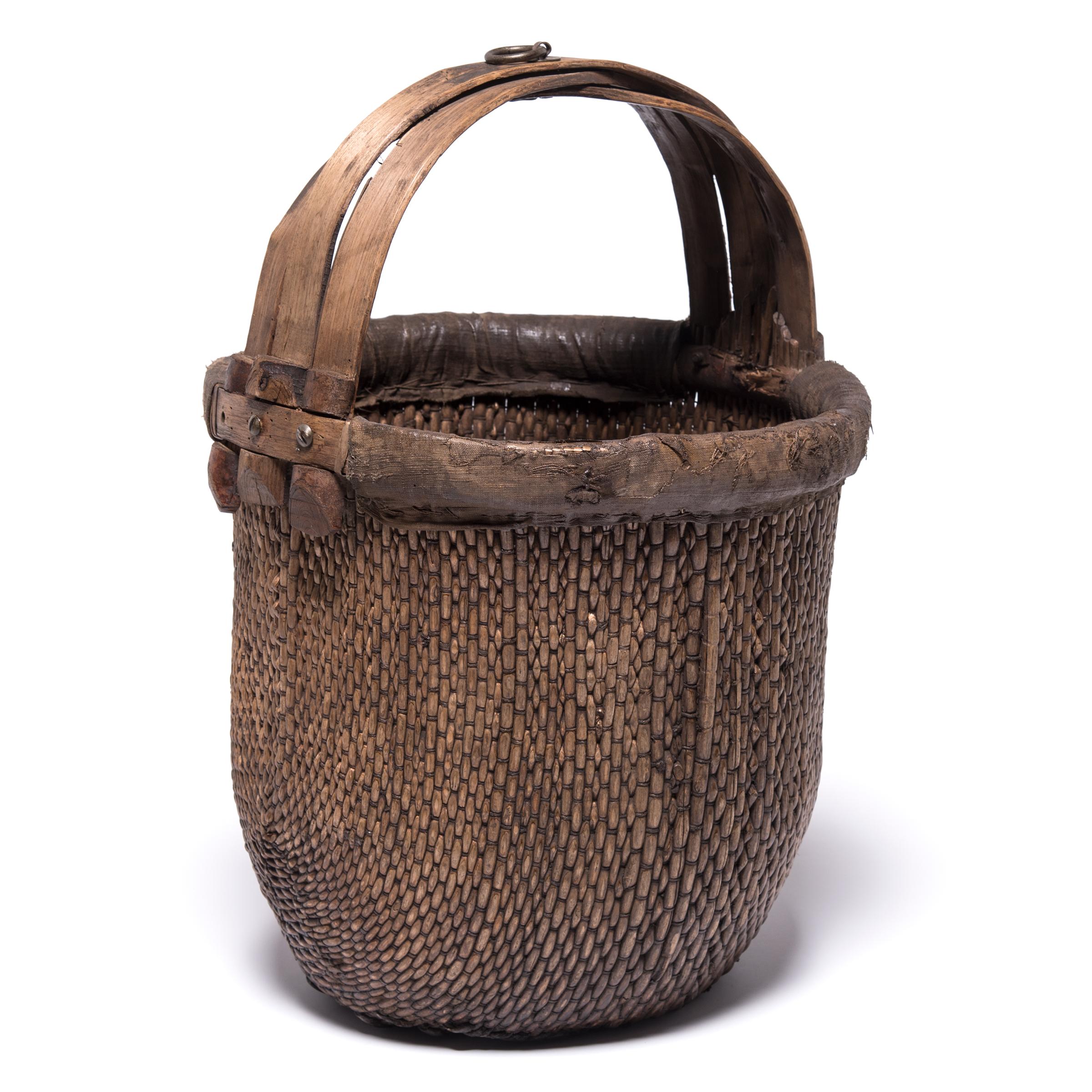 Basket making is an ancient and humble craft, but in the hands of a skilled weaver a simple willow basket becomes a truly beautiful statement. The artisan’s mastery is evident in this early 20th century bent handle basket: the strong, flexible