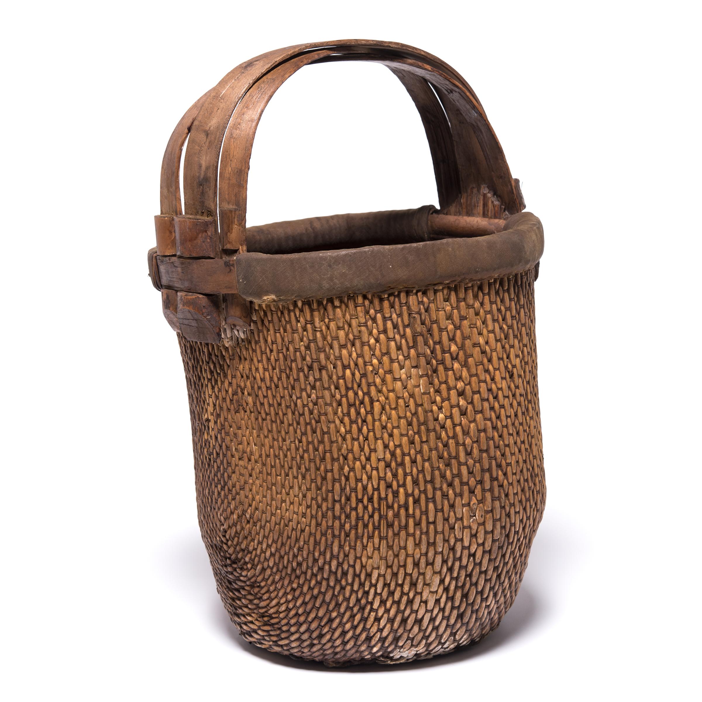 Basket making is an ancient and humble craft, but in the hands of a skilled weaver a simple willow basket becomes a truly beautiful statement. The artisan’s mastery is evident in this early 20th century bent handle basket: the strong, flexible