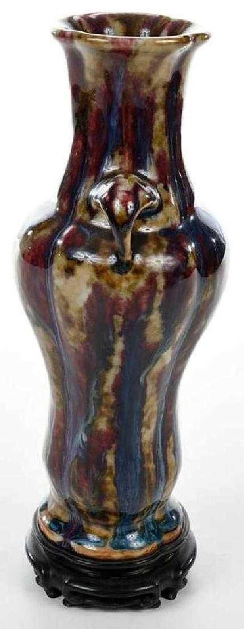 A fine Qing dynasty vase with iridescent flambé Yao Bian glaze of molded and ribbed form with elephant handles on carved hardwood stand.