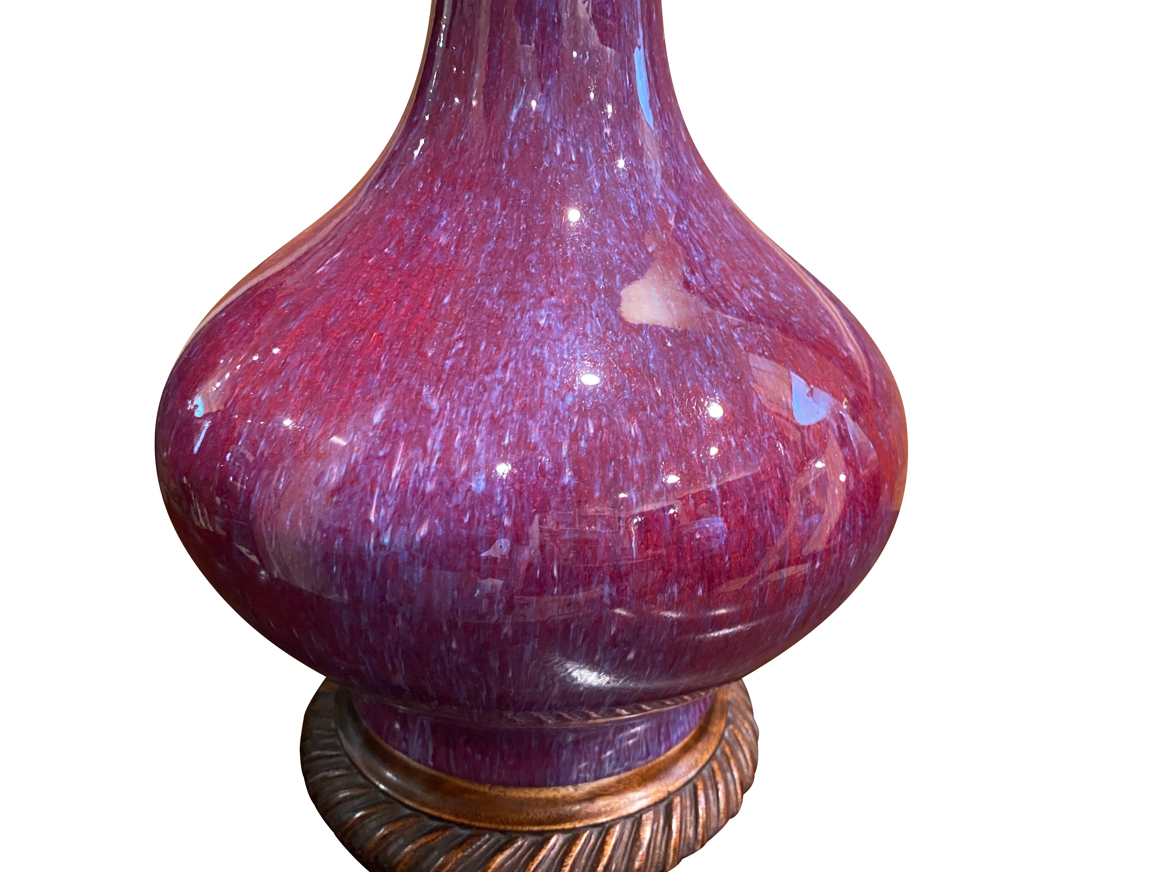 Bottle form vase with two candle sockets and carved wood base.