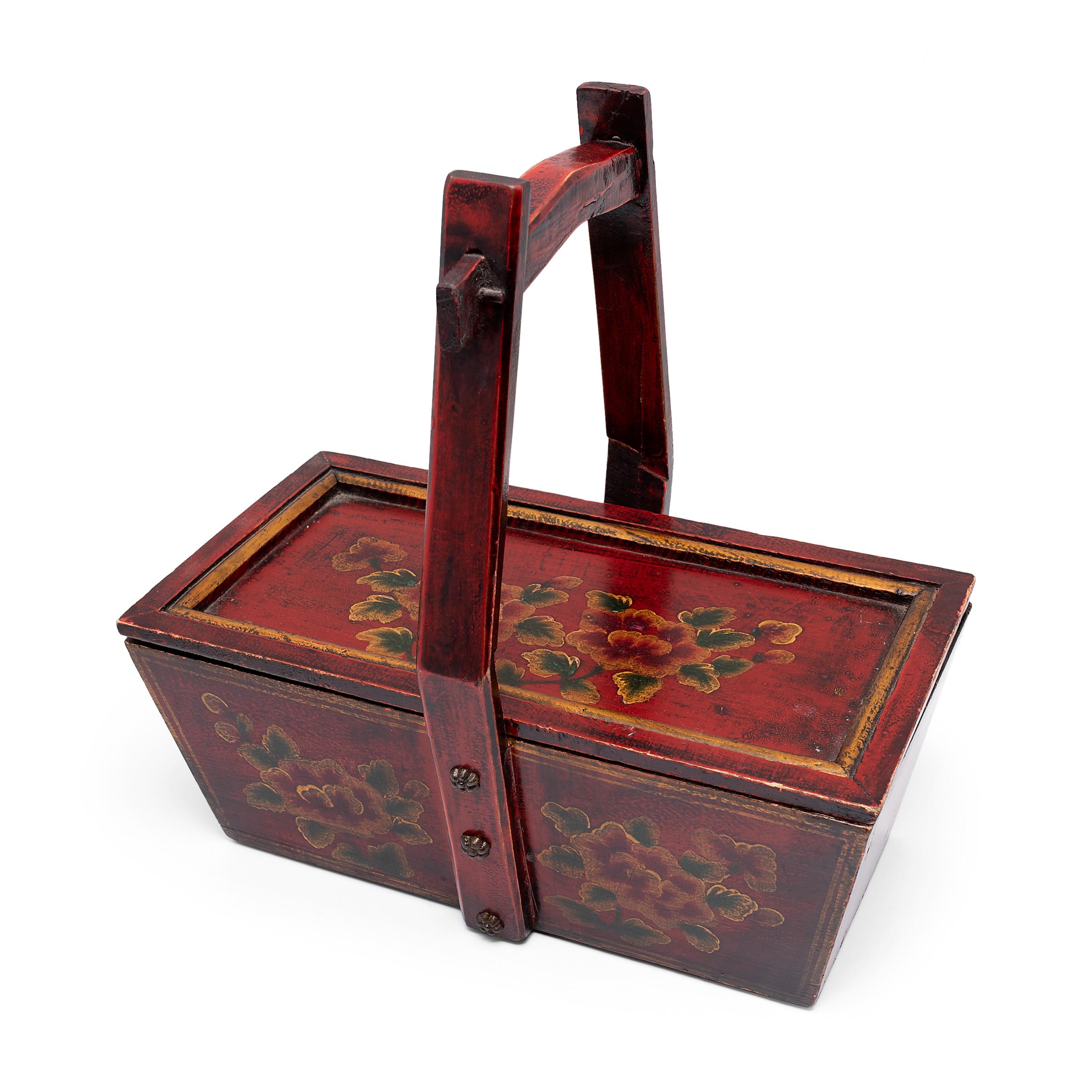 This painted carrying box is a mid-century example of the traditional containers used for transporting food, water, and other goods from place to place. The tall handle allowed the container to be placed on a carrying pole balanced across the