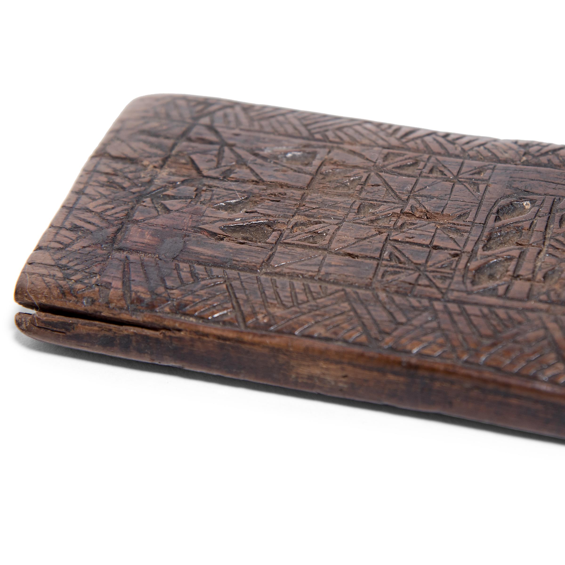 Dated to the 19th century, this flat wooden panel is curiously etched with geometric patterns, simple leaf motifs, and a triangle-work border. Its original use remains unknown - perhaps it was a divination tool, a traveling game board, or a weight