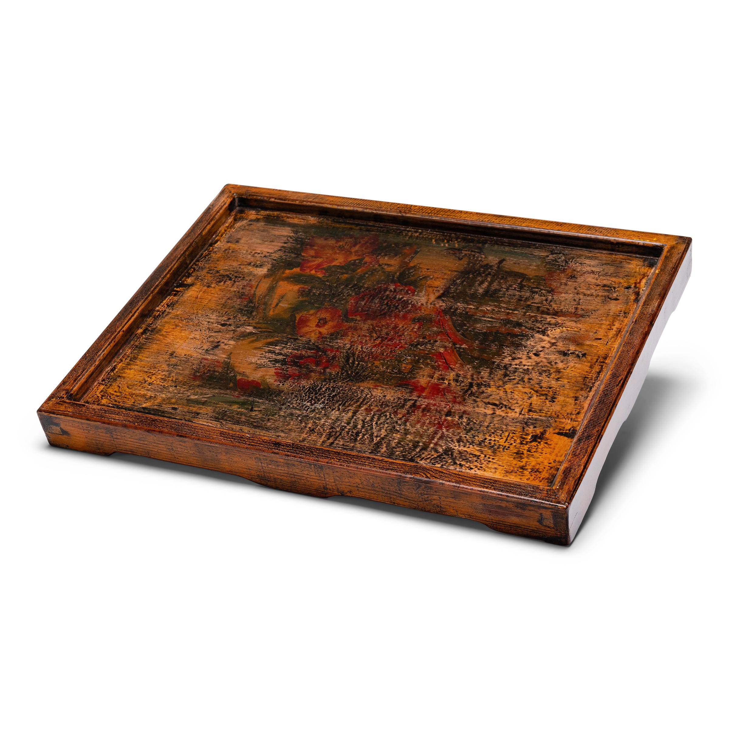 Dieses lackierte Serviertablett besteht aus einer handbemalten Platte, die aus einem alten chinesischen Schrank geborgen wurde. Die wegen ihres charmanten Volkskunstdekors ausgewählte Tafel ist mit einer Gruppe roter Blumen inmitten einer