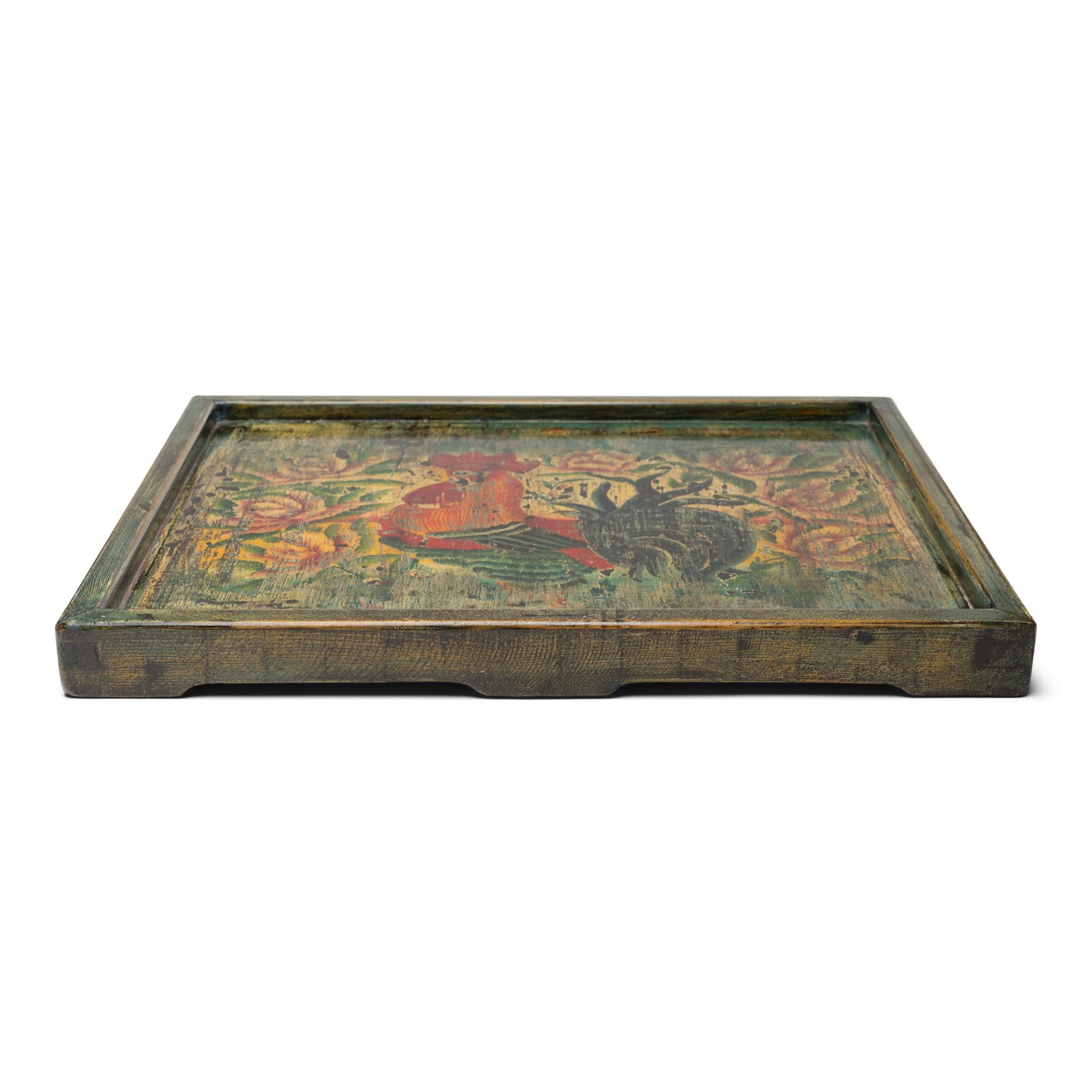 Dieses lackierte Serviertablett besteht aus einer handbemalten Platte, die aus einem alten chinesischen Schrank geborgen wurde. Die für ihre charmante Volkskunstdekoration ausgewählte Tafel ist mit einem krähenden, farbenfrohen Hahn inmitten eines