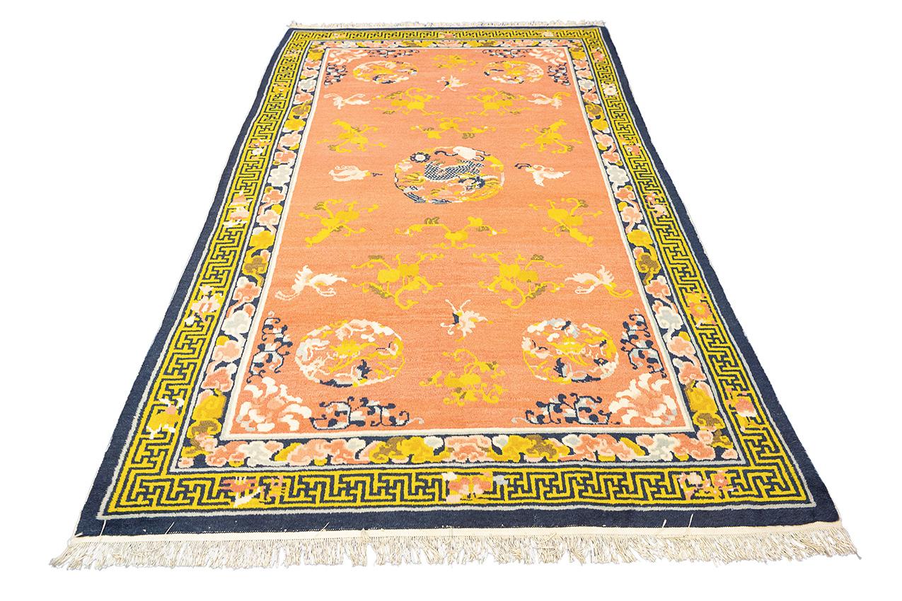 This is an antique Chinese Foo Dog Rug Salmon Color woven circa 1920. What sets this particular rug apart and makes it worth its price is its remarkable attention to detail and unparalleled aesthetic appeal. The color palette of salmon and gold