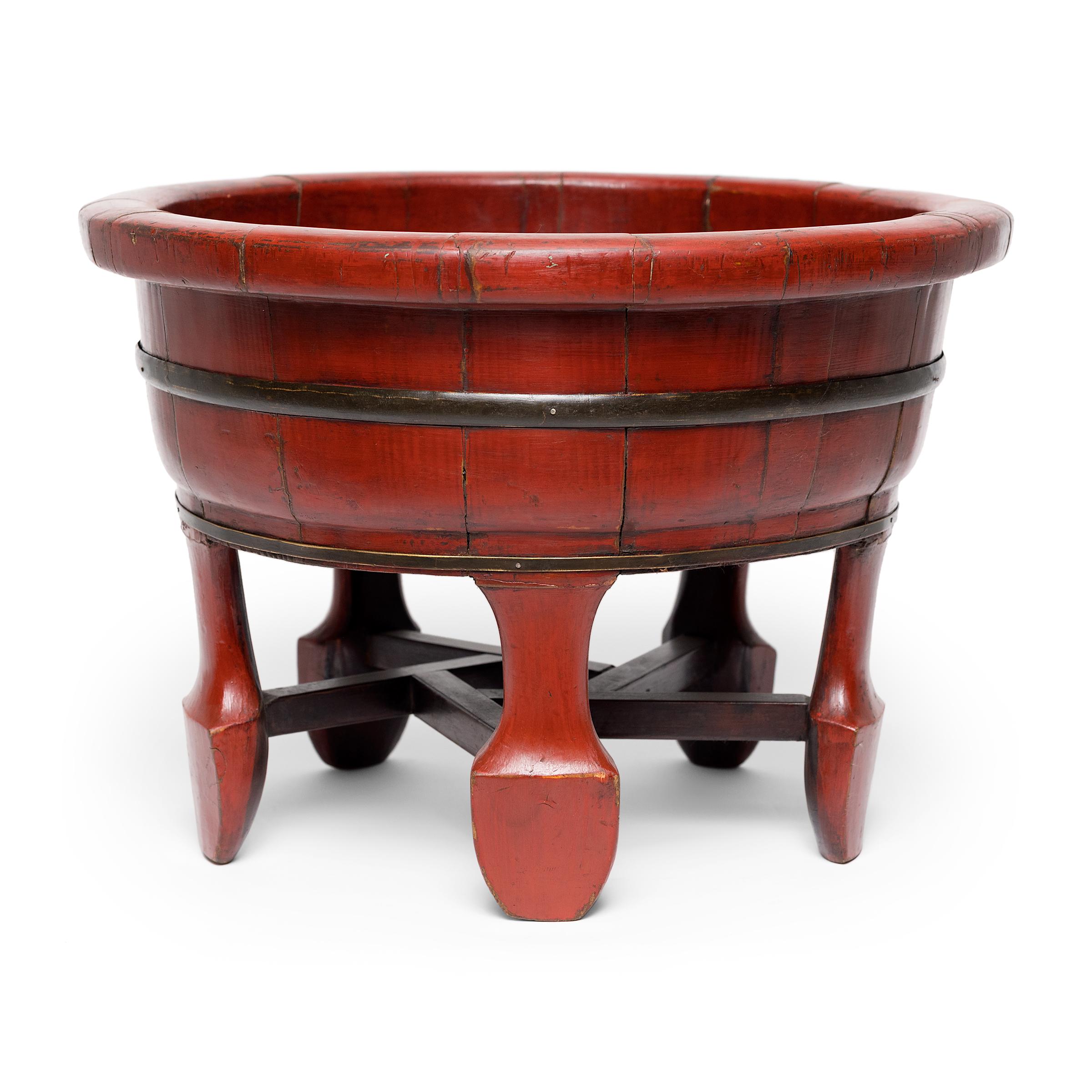 This raised lacquered vessel dates to the late 19th century and was originally used as an elevated wash basin or a child's bathtub. The round basin is raised on a footed base with five spade-form legs linked by interlocking stretchers. The tub is