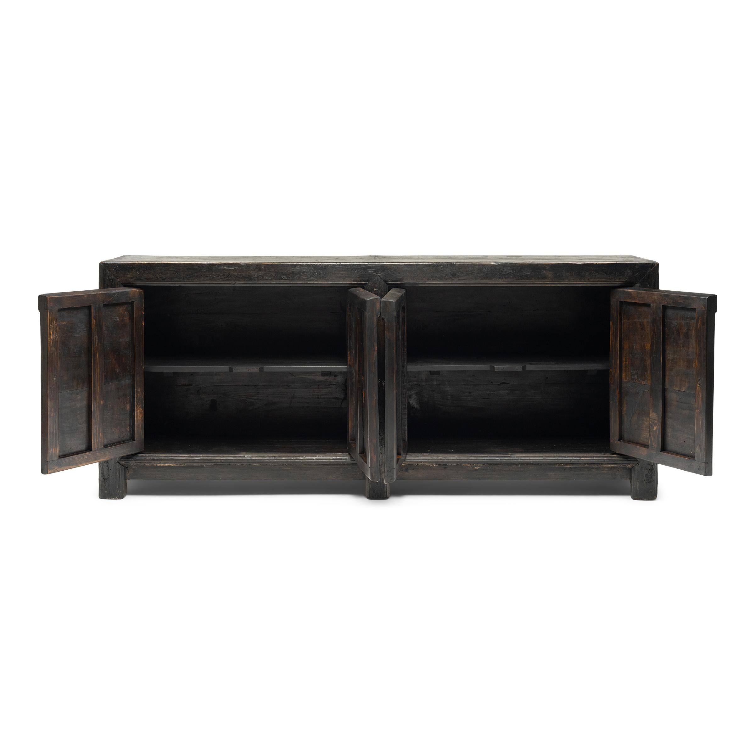 Questo forziere rustico dei primi del Novecento bilancia una silhouette snella con materiali strutturati e wabi-sabi. Realizzata in legno di pino con una falegnameria tradizionale, la credenza a quattro ante era originariamente configurata per