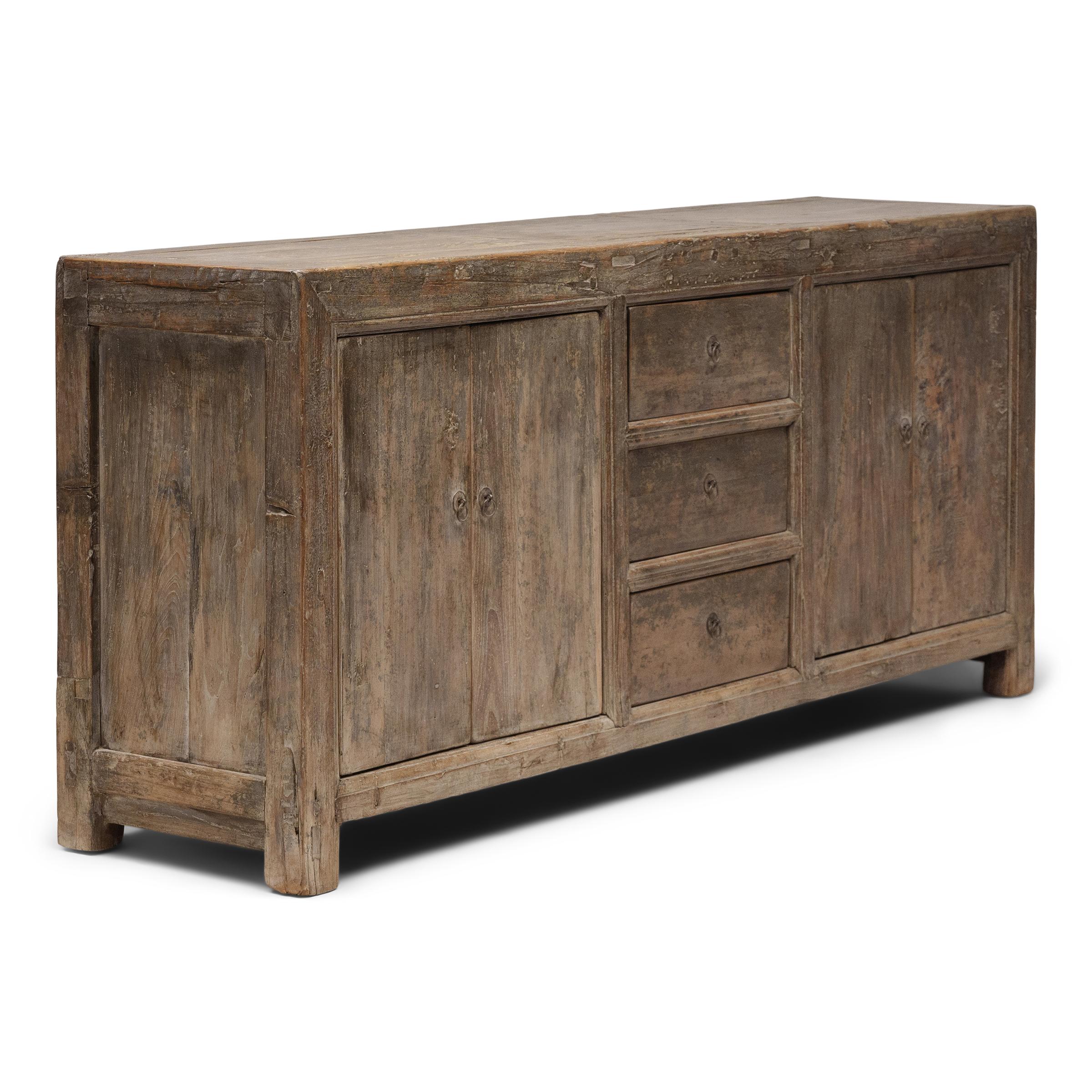 Created in the style of Mongolian storage coffers, this early 20th-century four door coffer has a minimalist design and plenty of rustic appeal. Originally configured to open from the top, the cabinet has been modified with front-facing doors by our