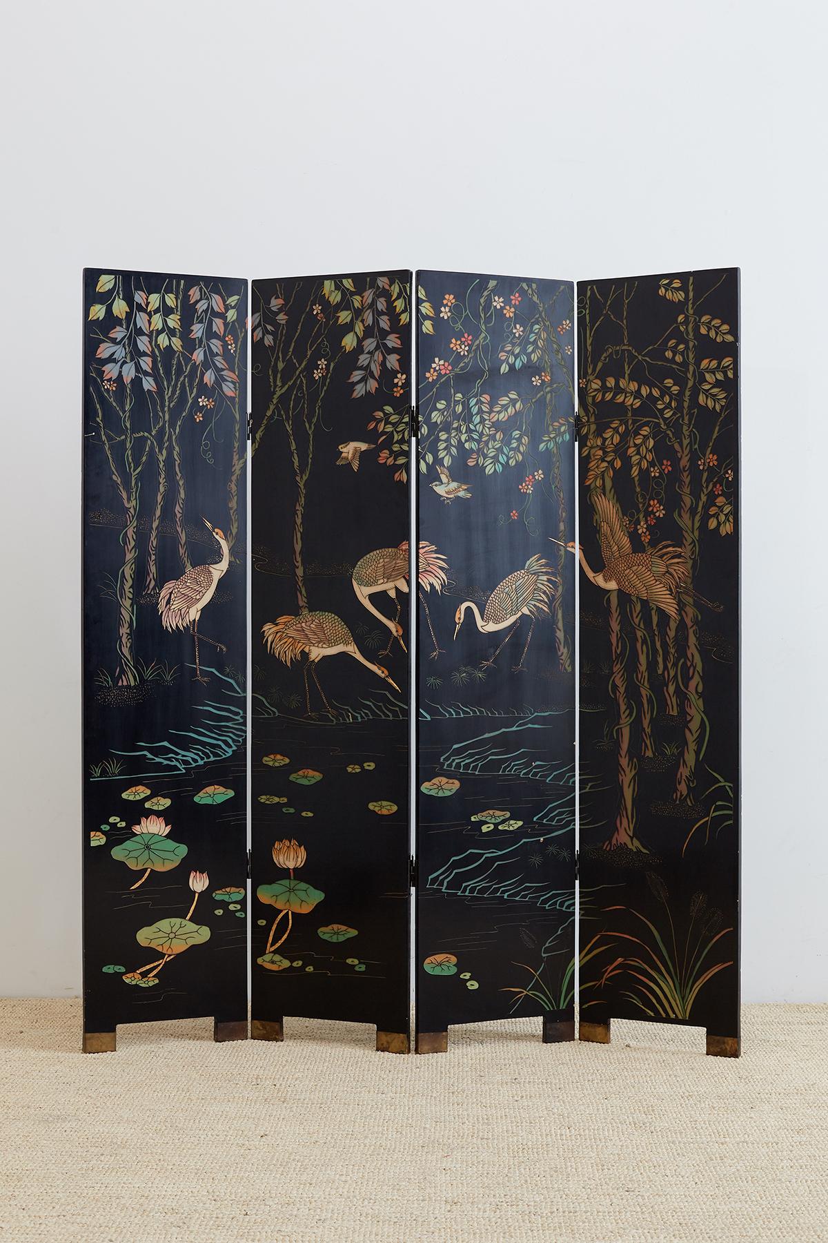 Gorgeous Chinese four-panel Coromandel screen featuring red-crowned cranes among trees and lotus blossoms. Dramatic color over a black lacquer background. Two-sided with the reverse having minimal decoration of bamboo, flower blossoms, and birds.