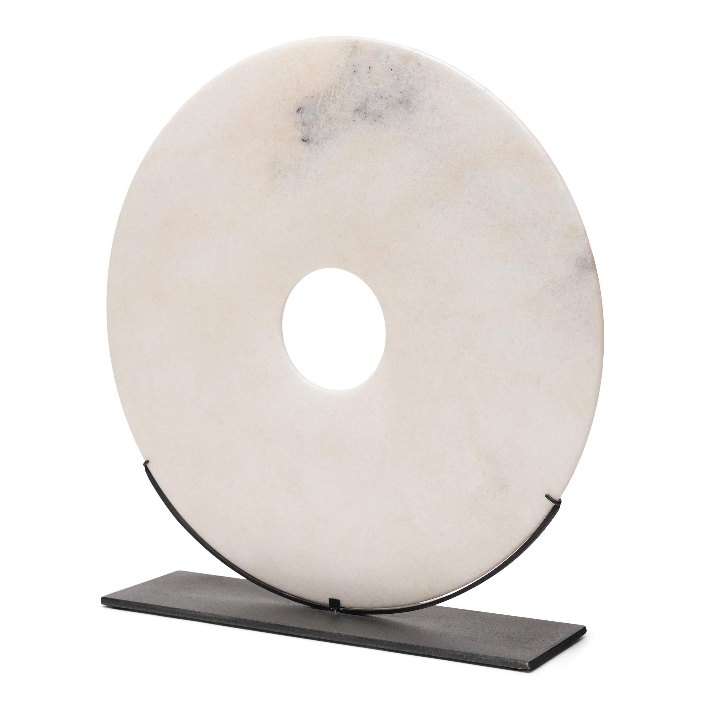 With its speckled white color and perfectly round form, this marble bi disc has a certain celestial quality, like a full moon gleaming in the night sky. Found in the tombs of ancient Chinese emperors and aristocrats, bi discs such as this have a