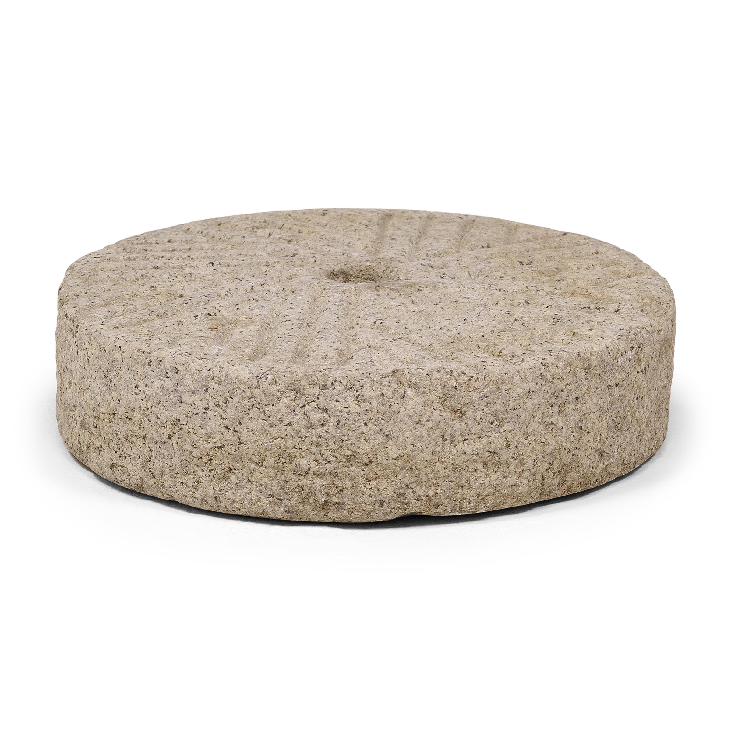 Questo grande disco di pietra veniva originariamente utilizzato in una casa cinese di provincia come pesante macina per macinare il riso e altri cereali in farina e semola. Scolpita a mano dal granito massiccio a forma di luna piena, la macina ha