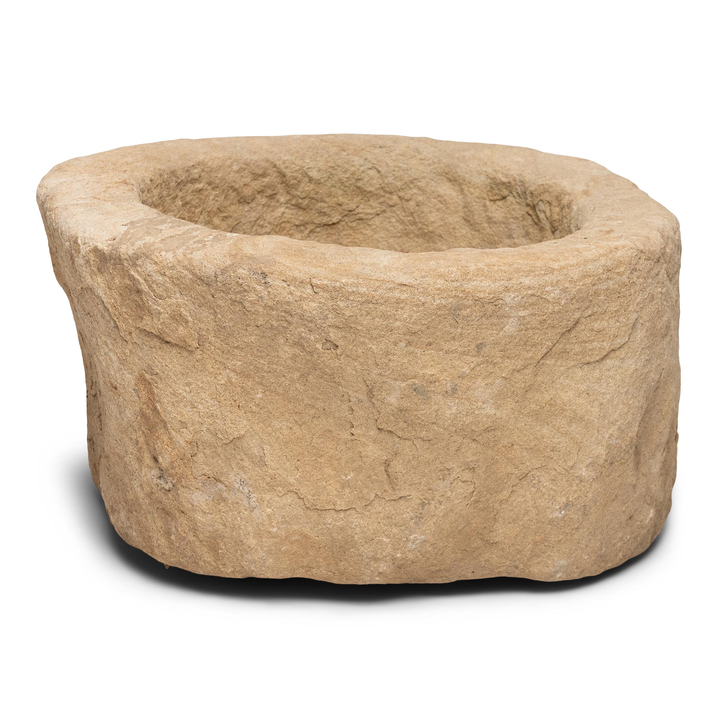 Once used on a provincial Chinese farm to hold water or animal feed, this early 19th-century stone trough is celebrated today for its organic form and rustic authenticity. The large trough is hand-carved from solid limestone to a rounded, full-moon