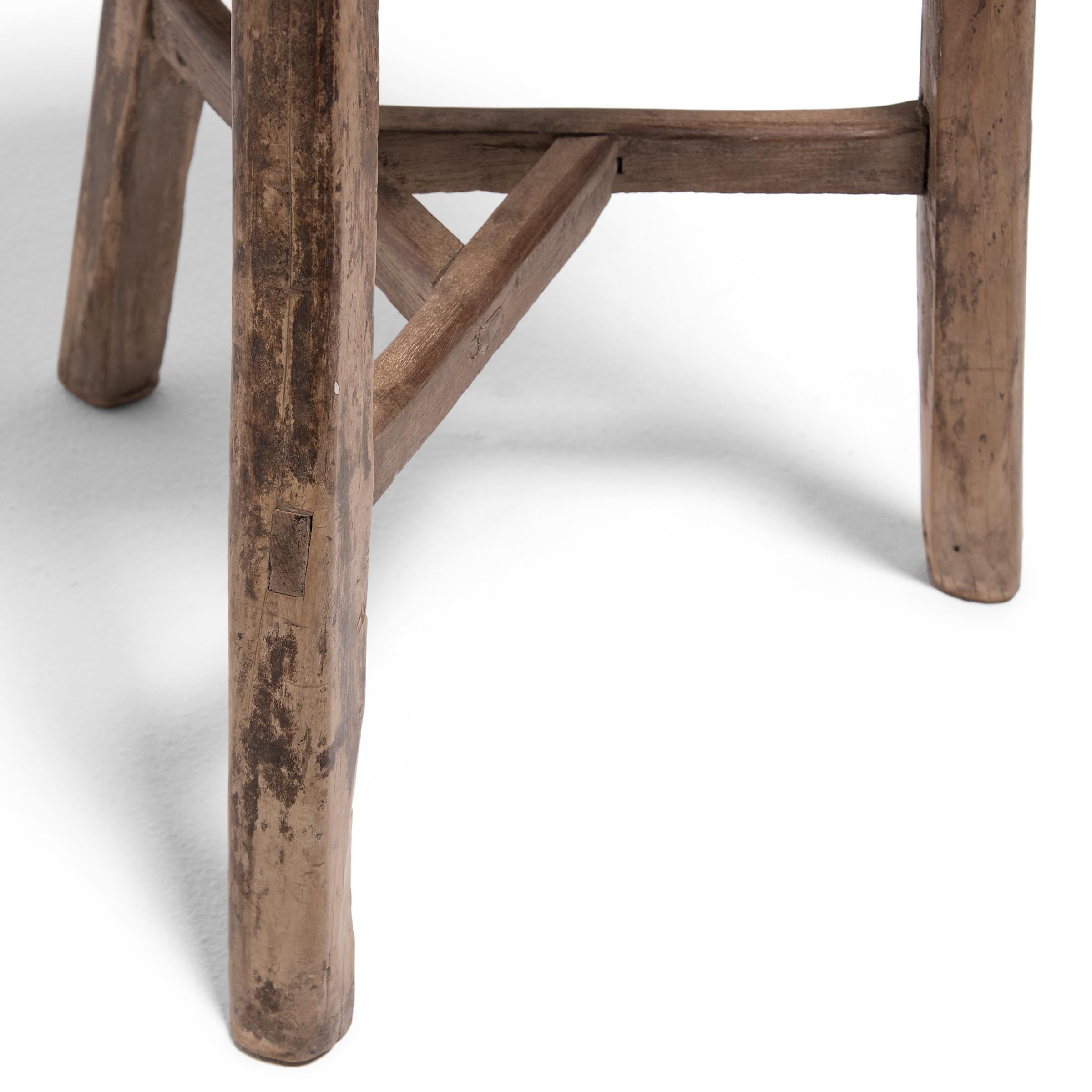Deceptively simple, this early 20th century stool from Hebei province shows off the ingenious joinery methods traditionally used by Chinese carpenters. The stool’s three splayed legs are supported by stretcher bars that interlock at the center to