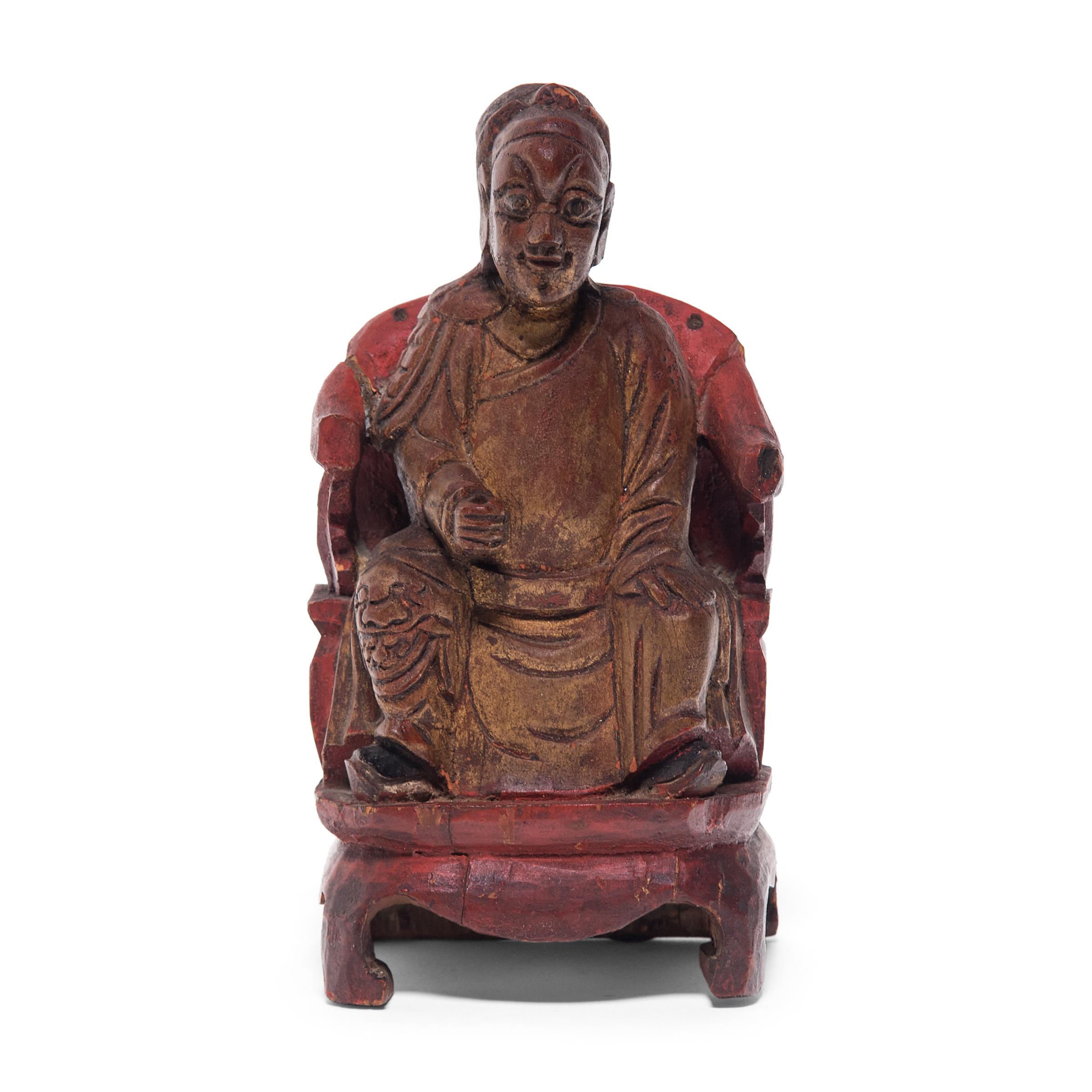 An integral part of traditional Chinese home life, ancestor worship before a domestic altar often featured painted ancestral portraits or tabletop ancestor figures. Seated upon a red roundback chair, this wooden ancestor figure bears the likeness of