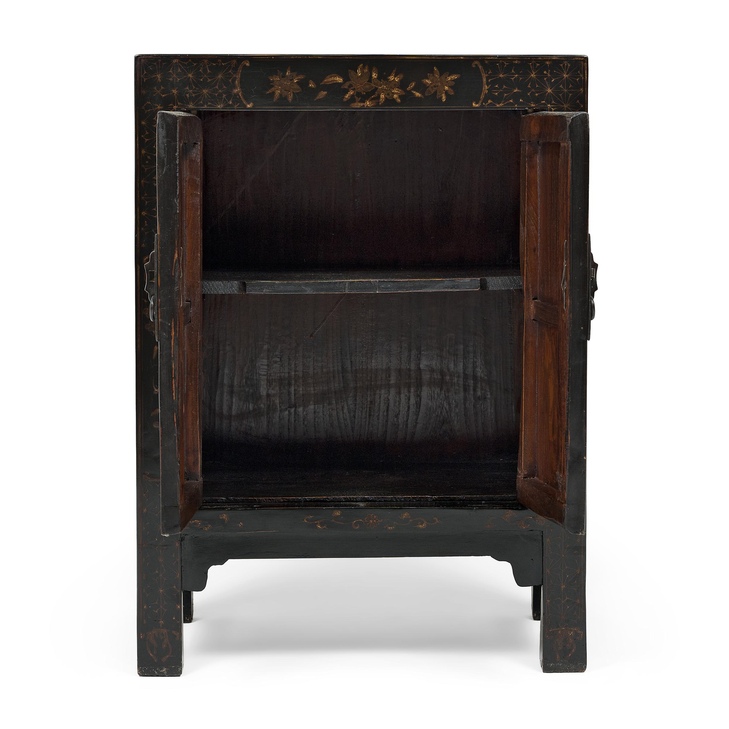 With clean lines and a dark lacquer finish, this small square corner cabinet provides the perfect canvas for intricate, hand-painted gilt decoration. Dated to the mid-19th century, the low chest is crafted of elmwood with a single interior shelf and