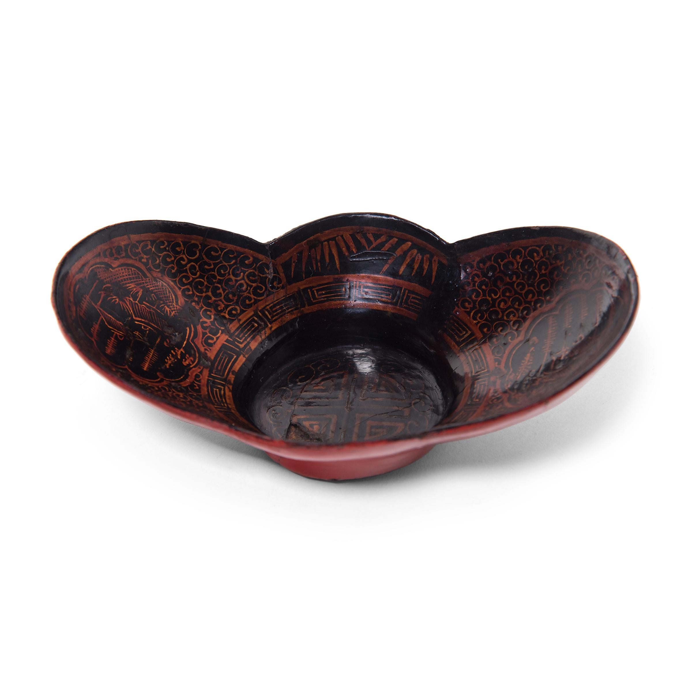 Dated to the mid-19th century, this petite cloud-form bowl was likely once used as an offering vessel atop a home altar, piled high with fruits, sweets, and other foods. The papier-mâché bowl is cloaked in red and black lacquer and elaborately