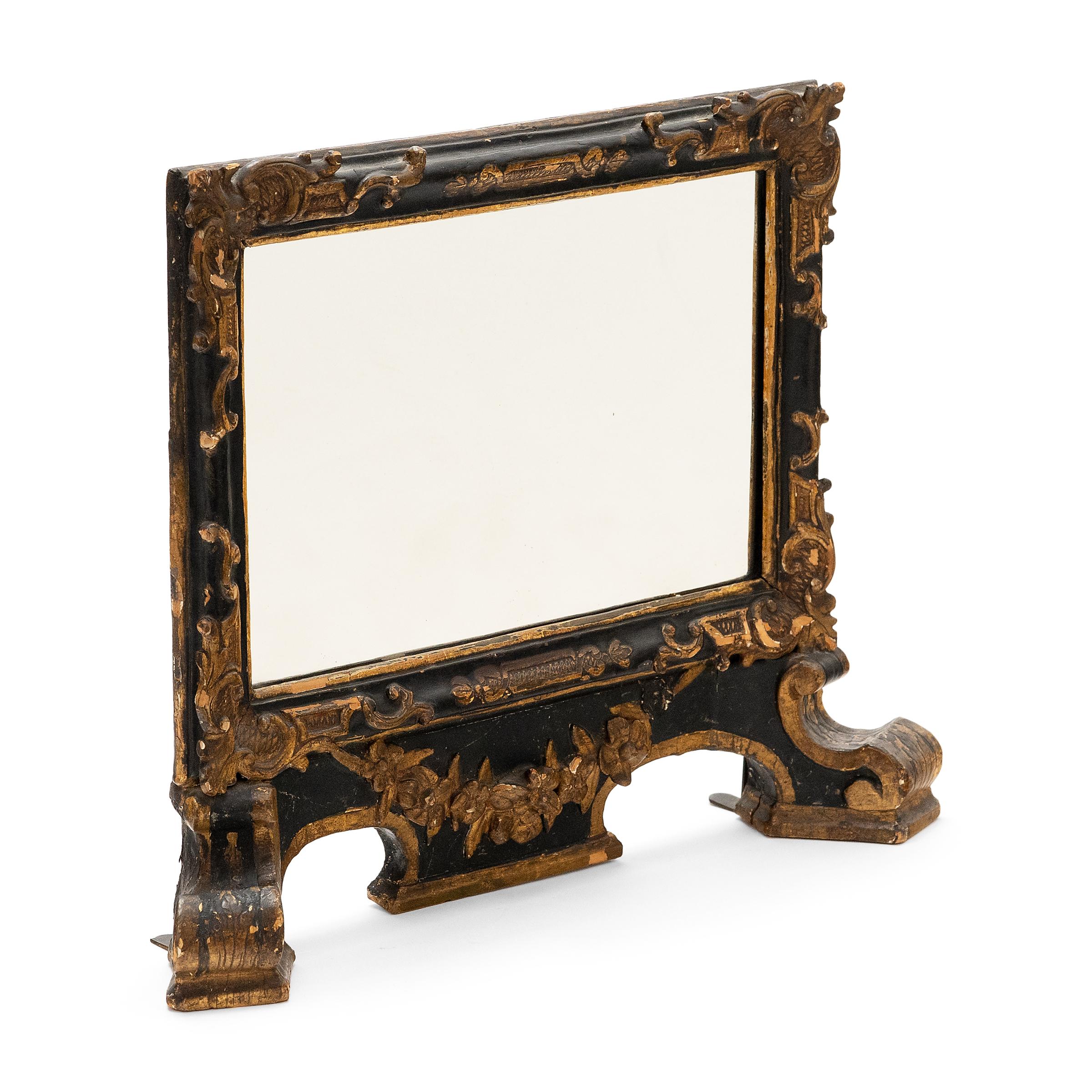 With intricate construction and exquisite decoration, this late-19th century table mirror is a true masterpiece of Chinoiserie-style craftsmanship and lacquerware. Decorated in gilt, the black lacquered wooden frame was shaped, embossed and chiseled
