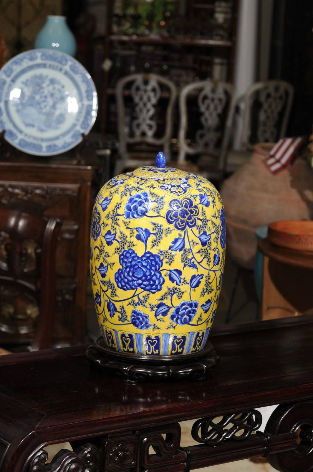 A lovely ginger jar with lid, a round body and tapers at the bottom. It is painted overall with a bold yellow background and beautiful shade of blue floral design. Excellent condition.