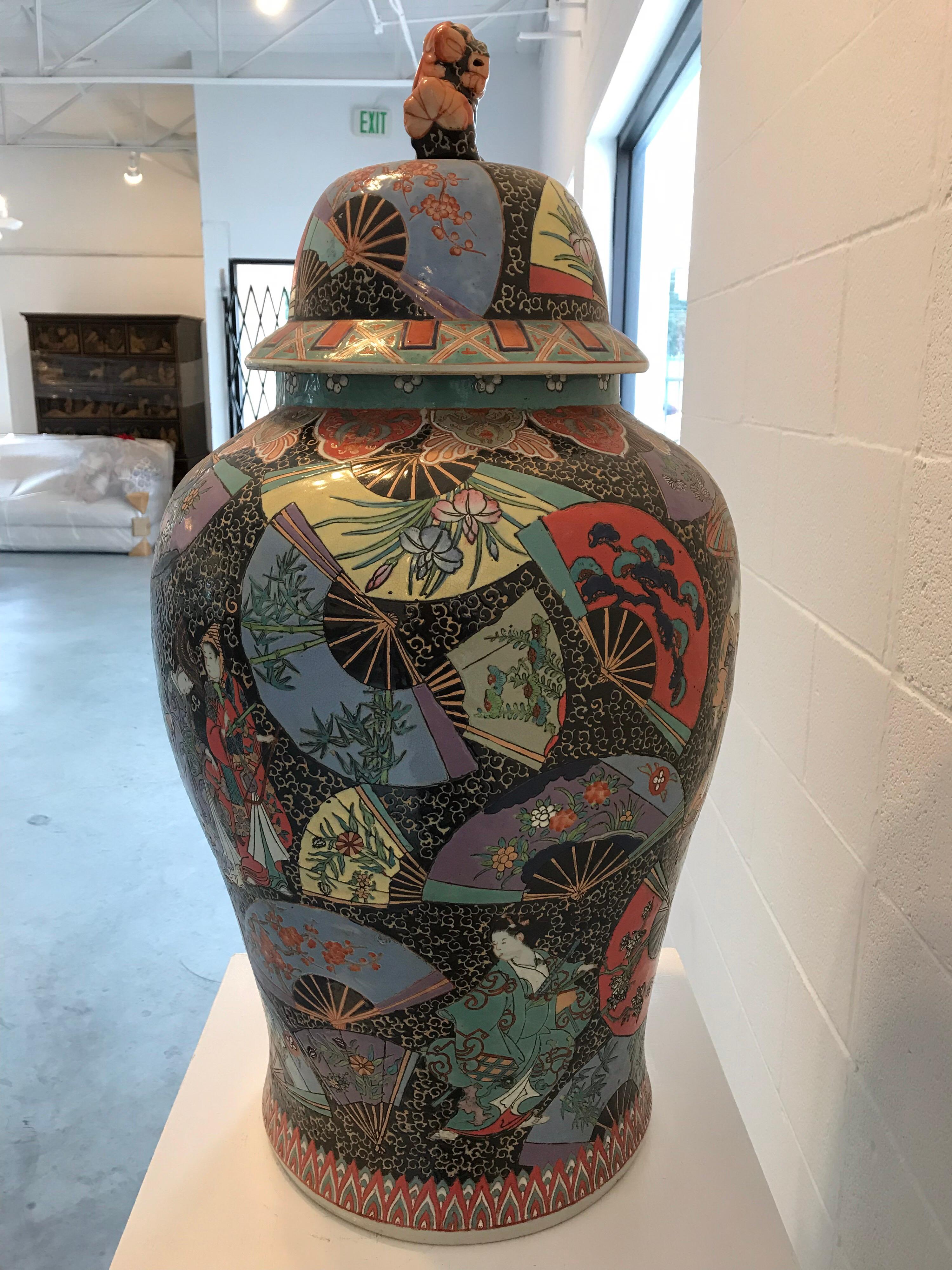 This large 1950s Chinese ginger jar is made of many bright, contrasting and vibrant colors. The cover of the jar has a foo dog on top of it adding some authentic Chinese decoration.