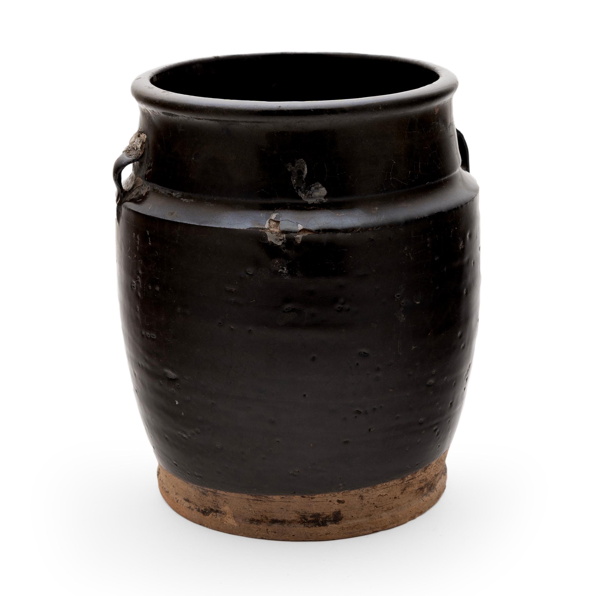 A cool, blue-black glaze coats the stout body of this early 20th-century terra cotta kitchen jar. As evidenced by the glazed interior, the wide-mouth jar was once used daily in a provincial Chinese kitchen for fermenting foods and condiments. The