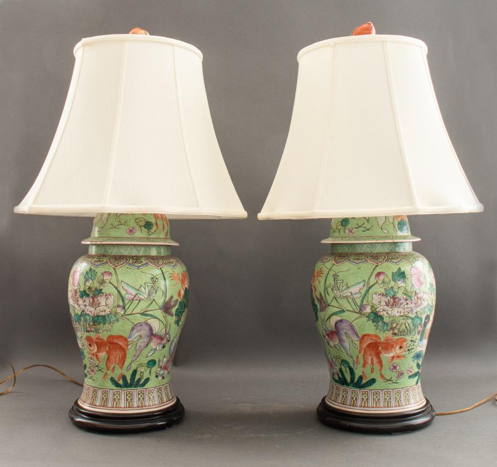 Pair of Chinese glazed ceramic table lamps, of covered ginger jar form, and each decorated with lotus flowers and aquatic life, the top with peach-form porcelain finial.

Dimensions: 36