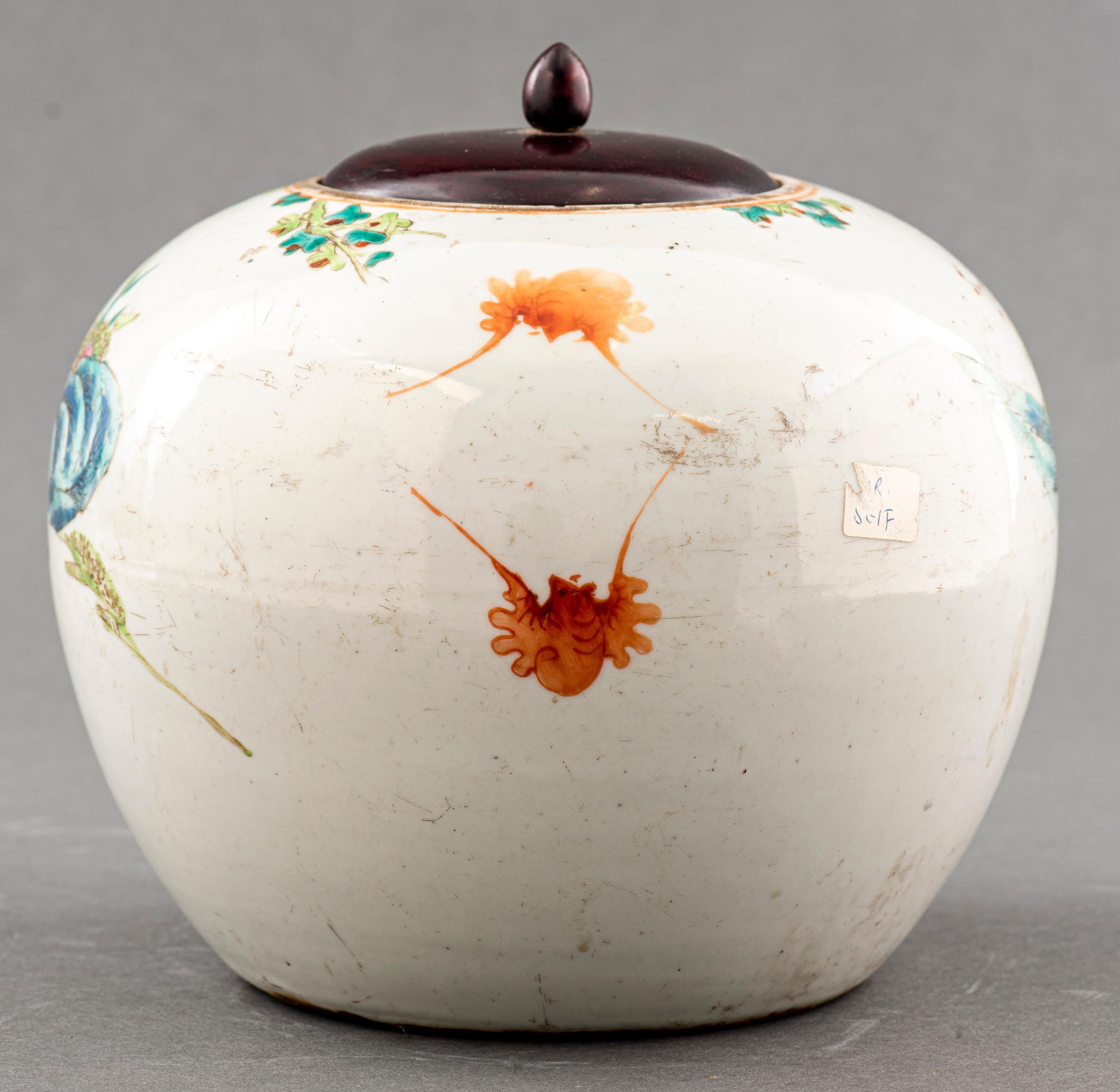 Chinese globular form jar, 19th century, with later wood lid, painted with various figures holding auspicious objects in a garden. 
Dimensions: 8.5” height x 10.25” diameter.