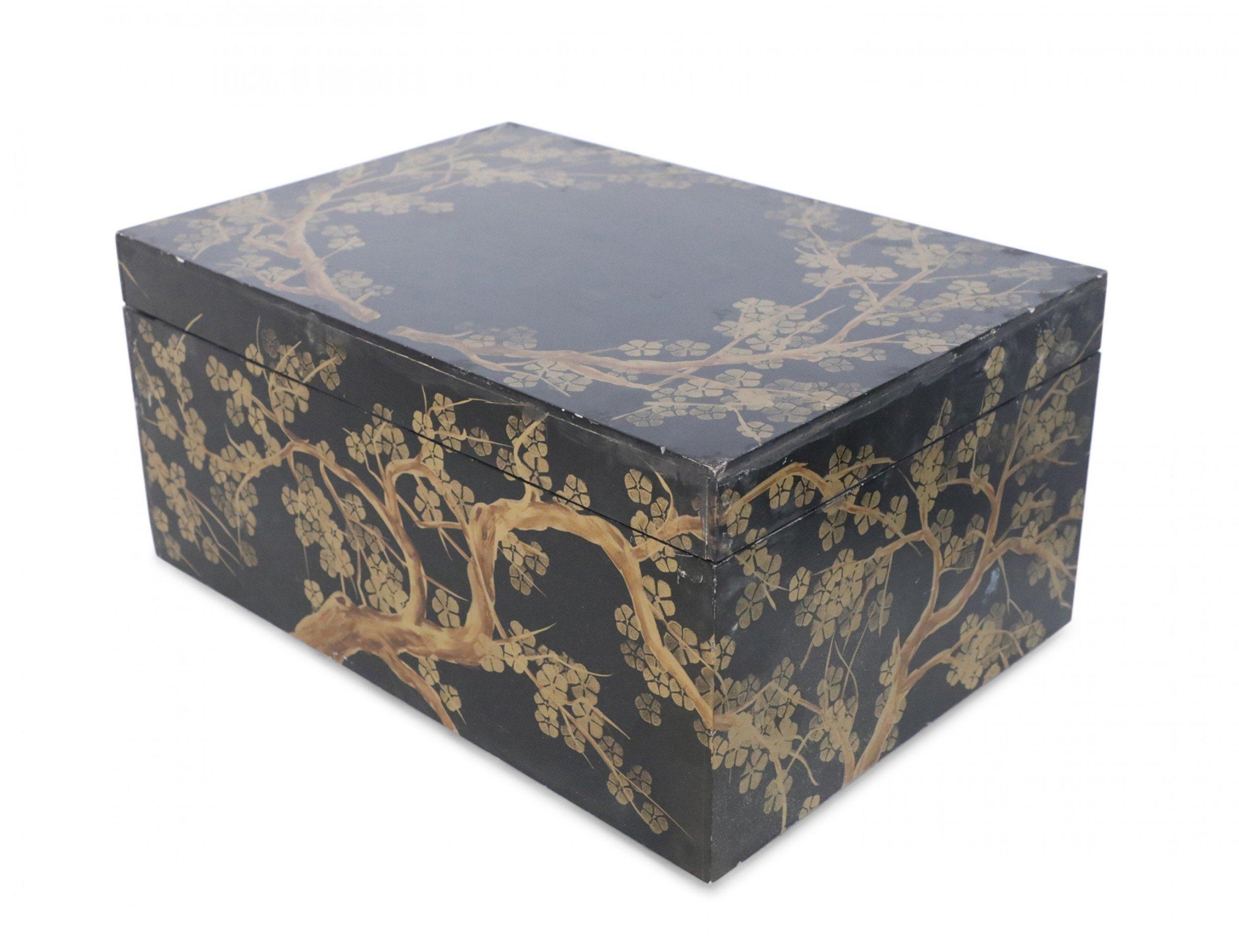 Chinese large decorative wooden box with gold cherry blossom design on top and sides against a black background, with a hinged lid, and small hidden feet.
 
