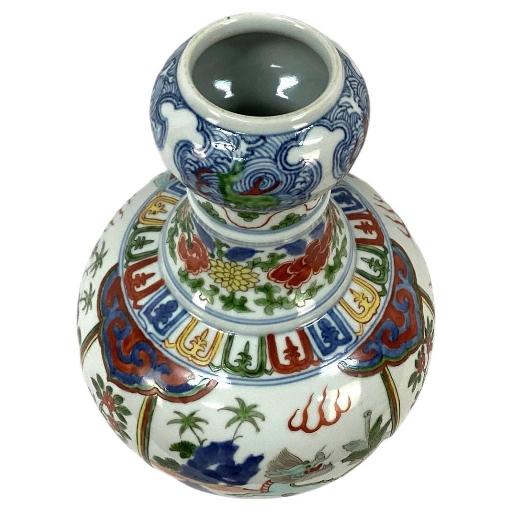  Chinese Gourd Shaped Porcelain Dragon Vase in rich colors of red, blue, green and yellow on a white background. Features multicolored dragons with flora and flowers. Chinese markings on bottom. In very good condition.